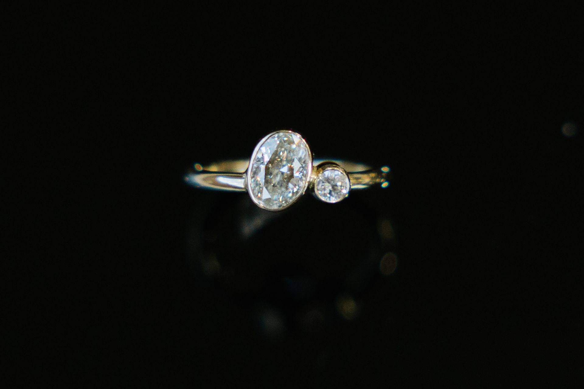 A close up of a diamond ring on a black background.