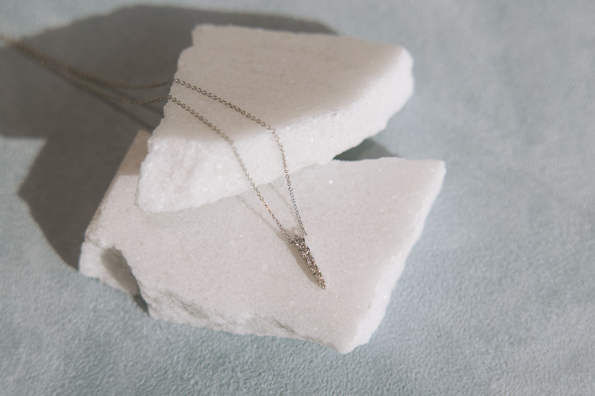 A necklace is sitting on top of a piece of marble.