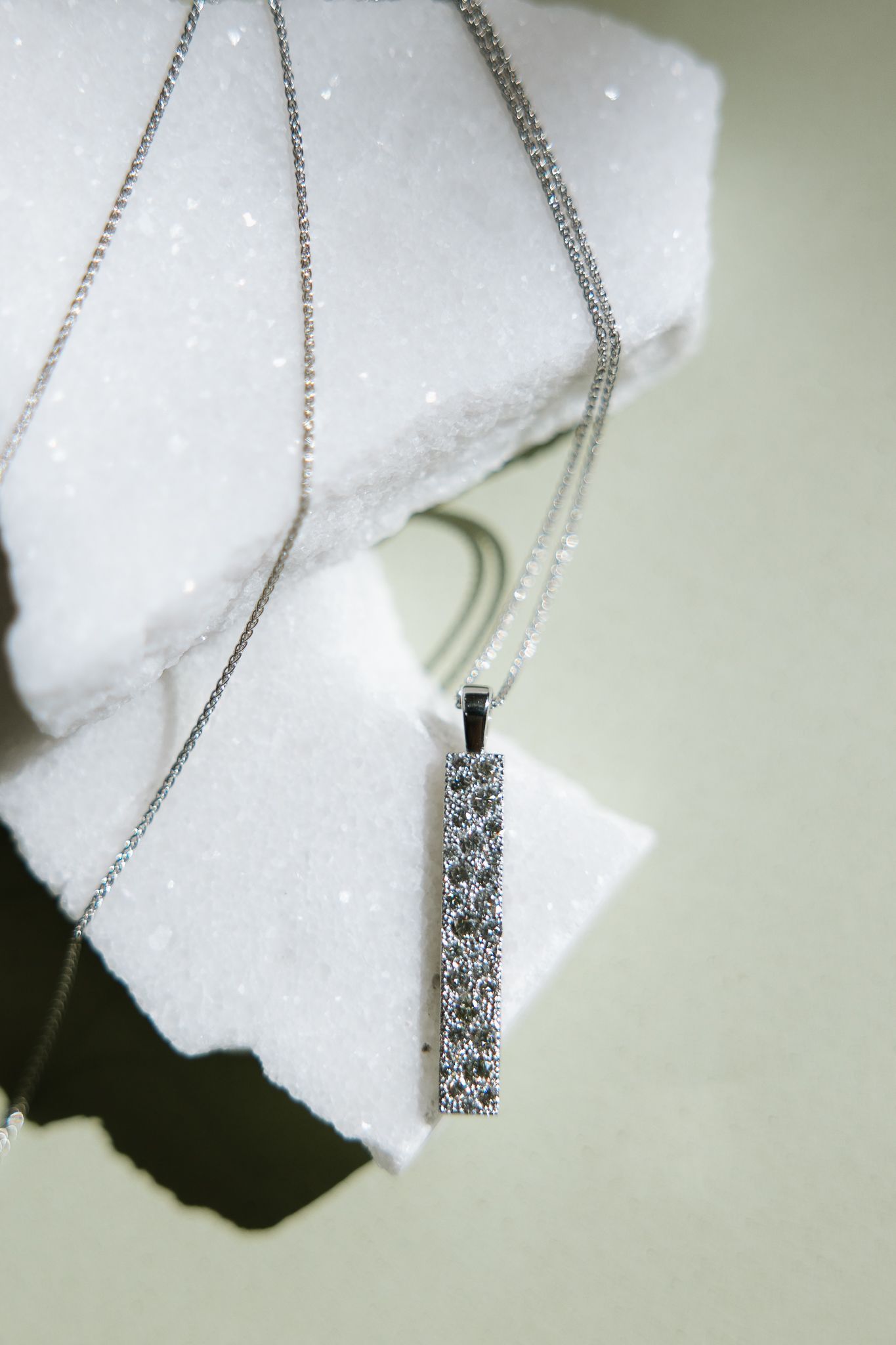 A necklace with a diamond pendant on a chain