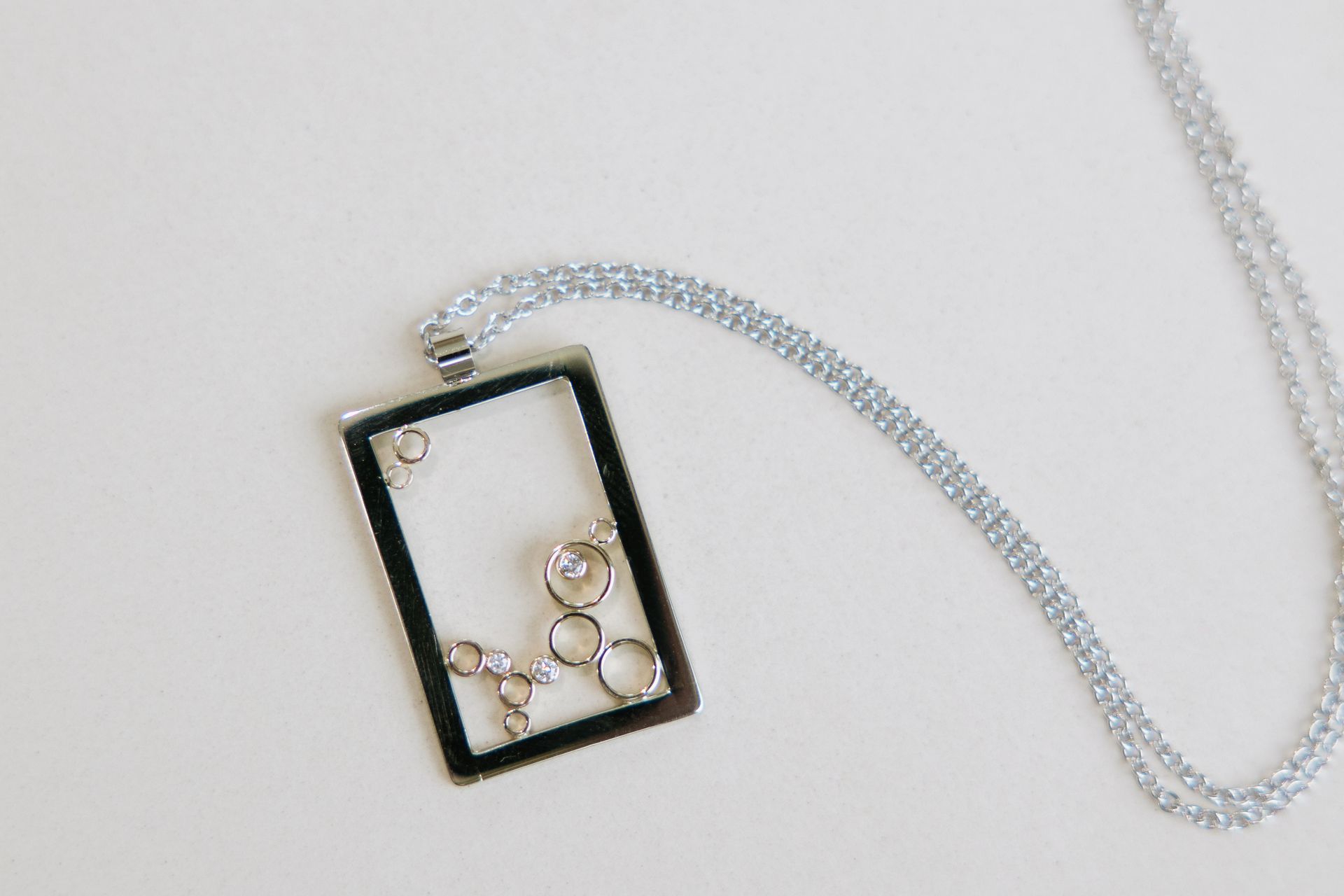 A necklace with a square pendant on a chain