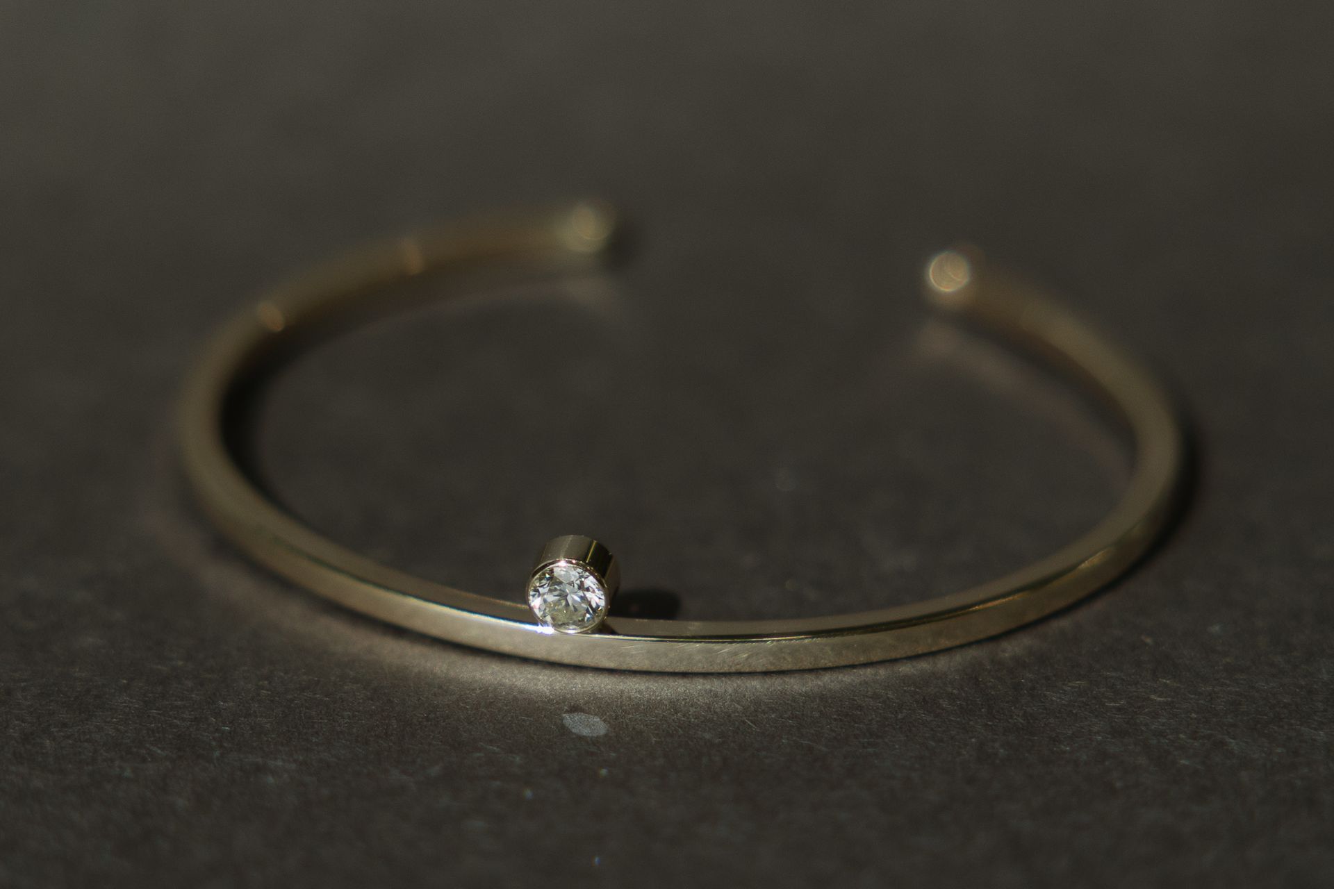 A close up of a bracelet with a diamond on it