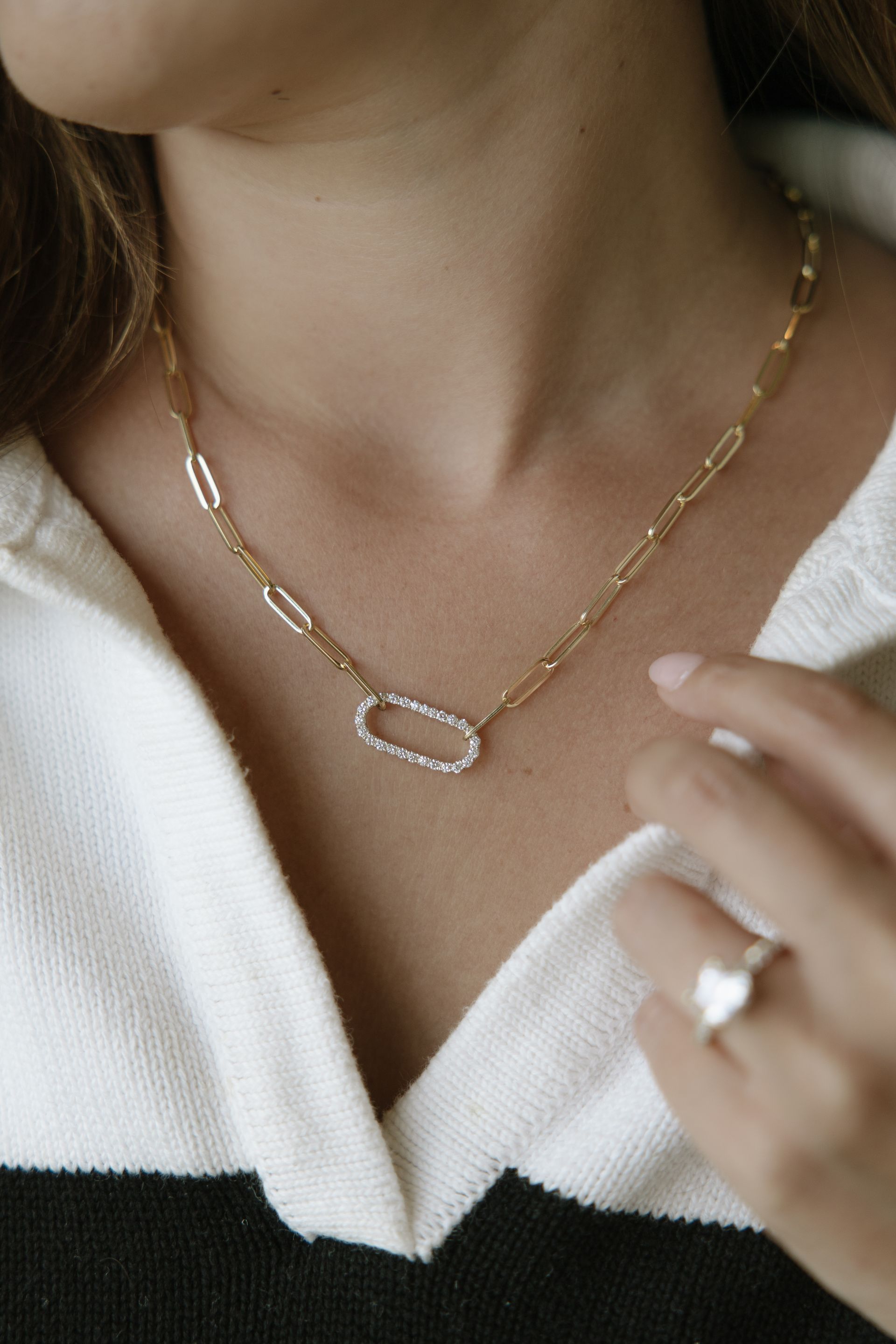 A woman is wearing a necklace and a ring.