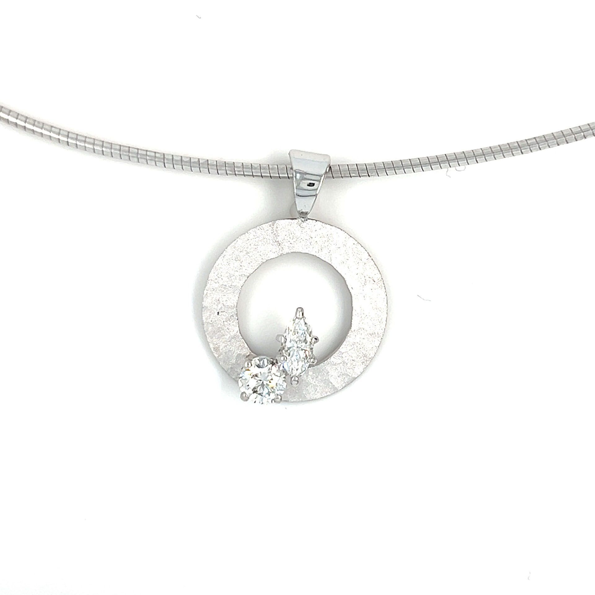 Silver necklace with a circular pendant with two white gemstones