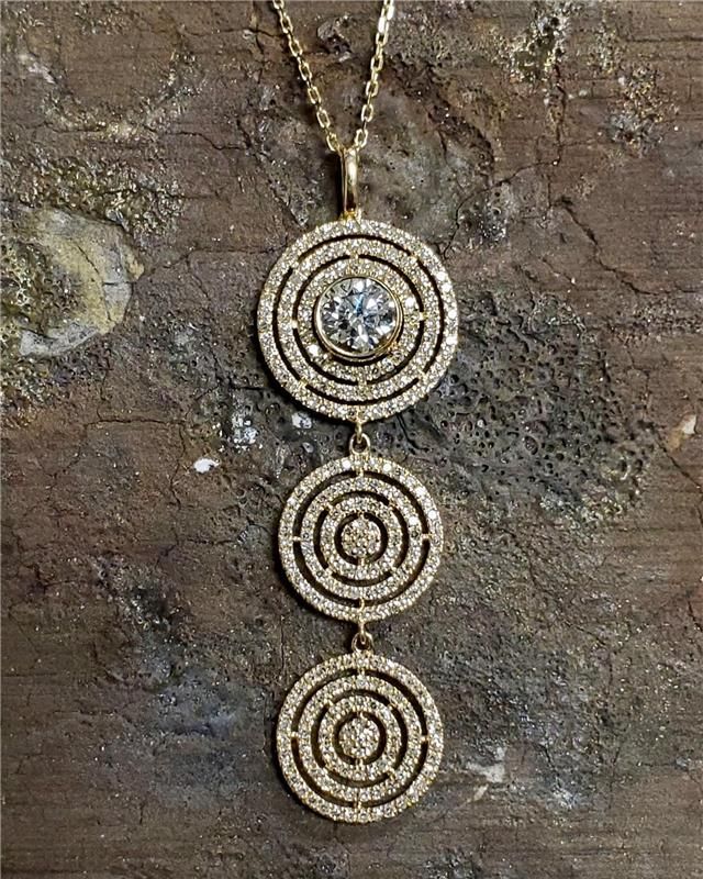 Gold pendant necklace with three diamond-encrusted concentric circles suspended from a chain.