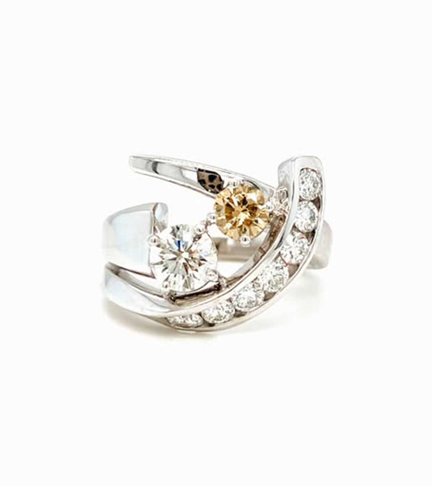 Diamond ring with white and yellow gems set in a swirling silver band