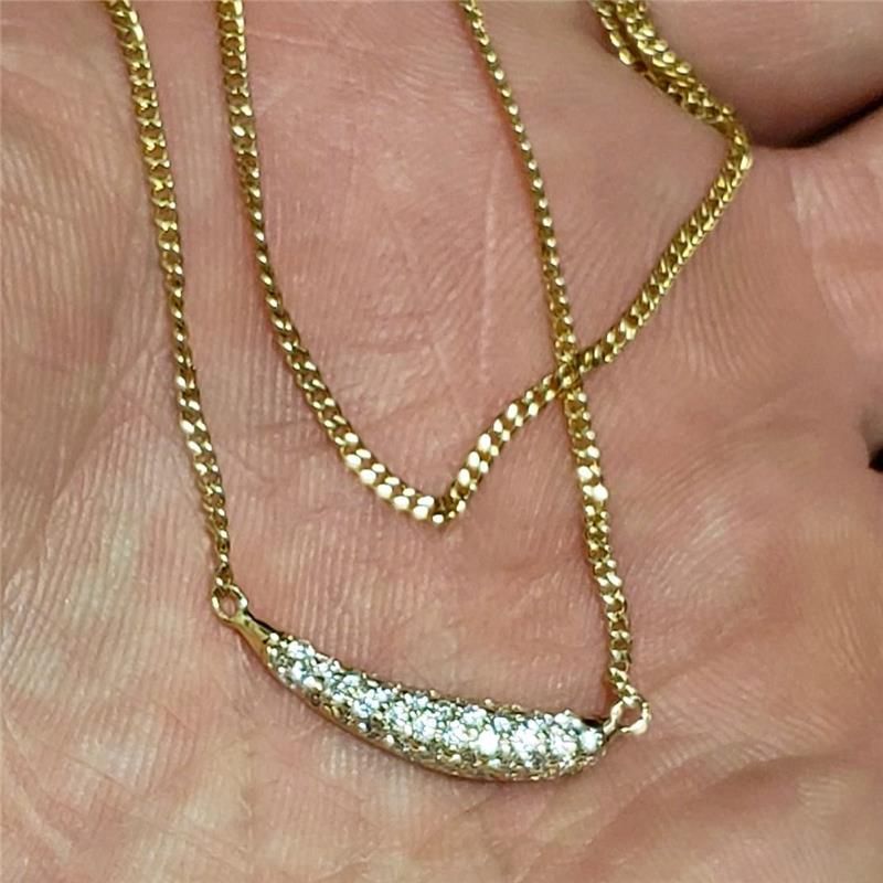 Gold necklace with small diamonds on a person's palm.