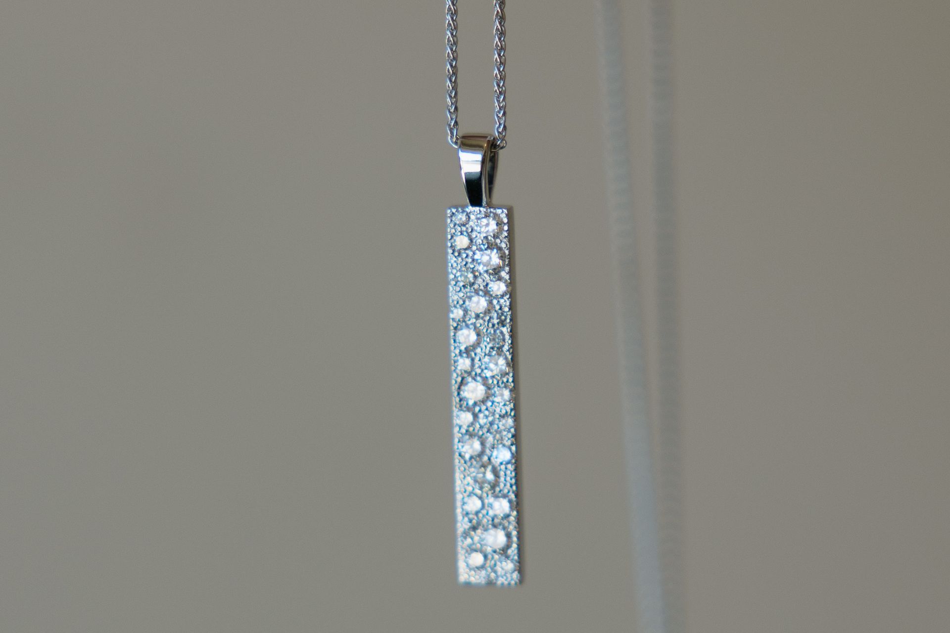 Silver pendant necklace with vertical bar of sparkling stones.