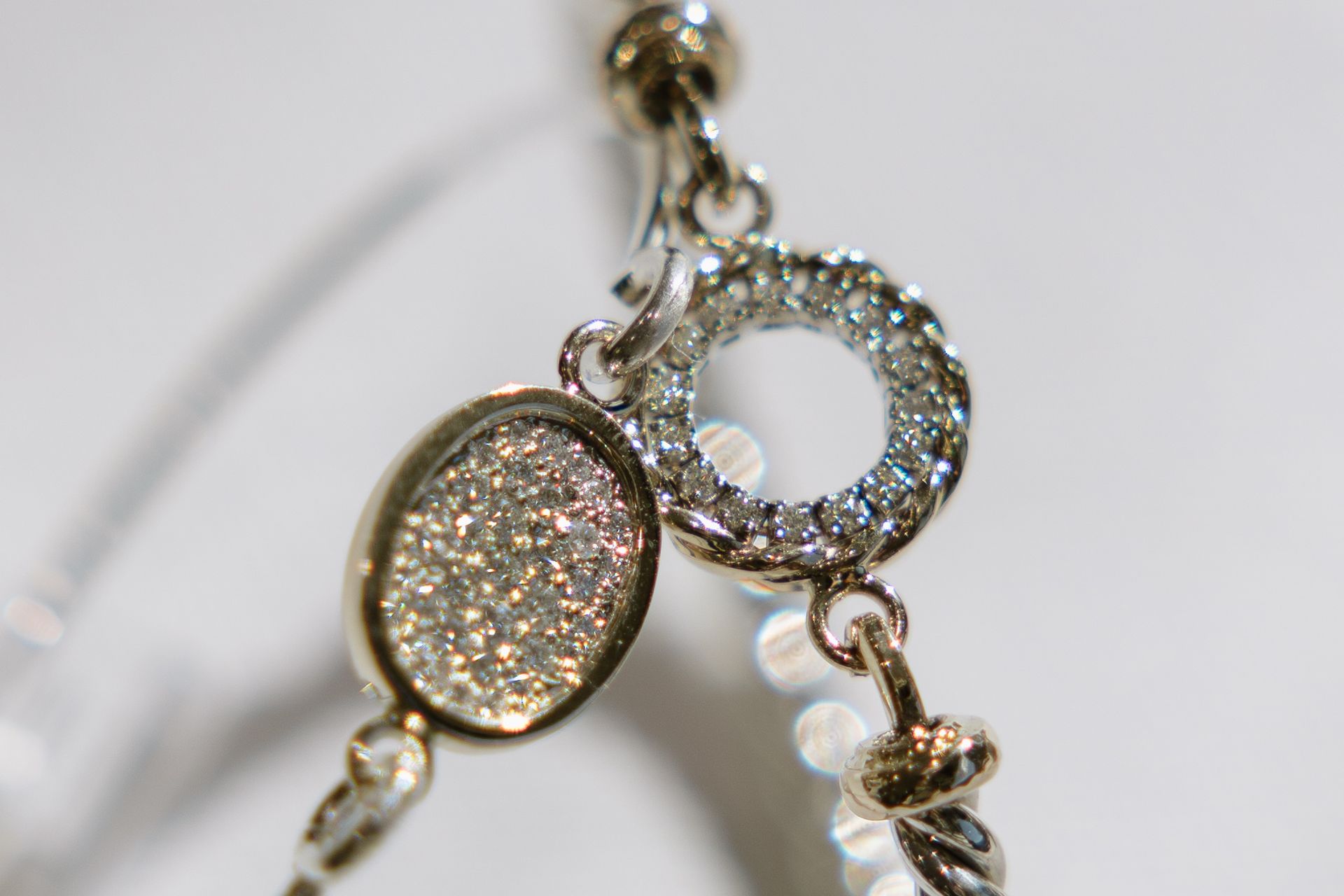 Silver necklace clasp with diamond accents and an oval stone.