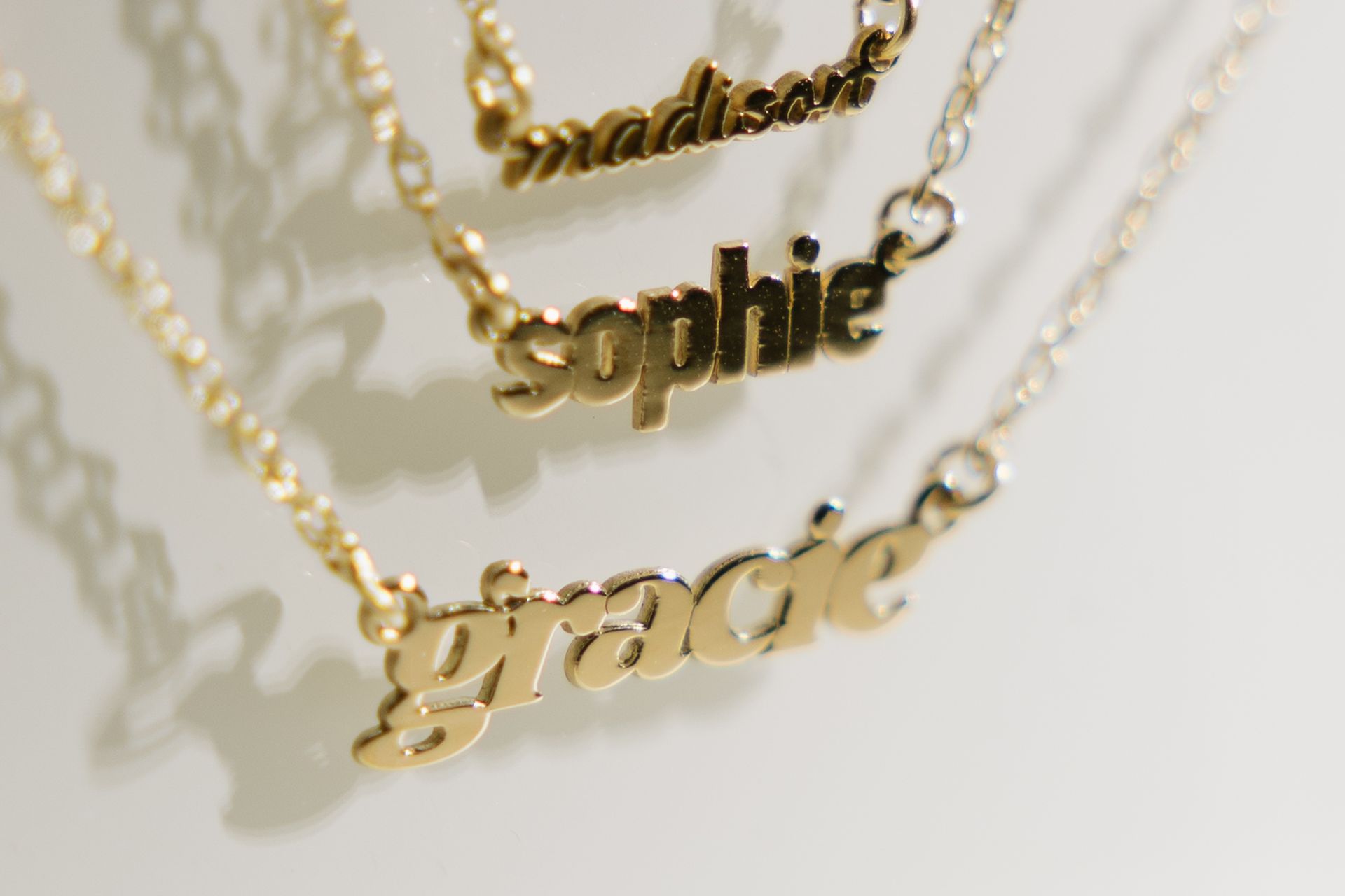 Three gold nameplate necklaces: 