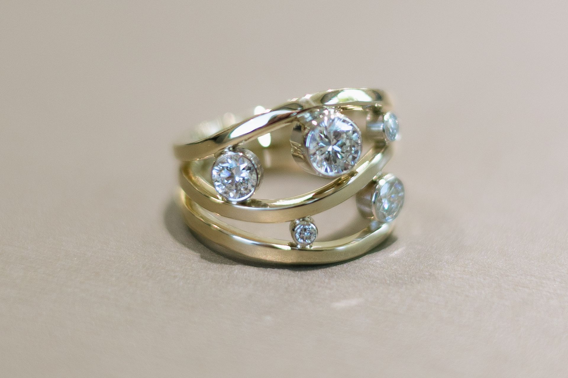 Gold ring with multiple bands, accented with round, clear gemstones.