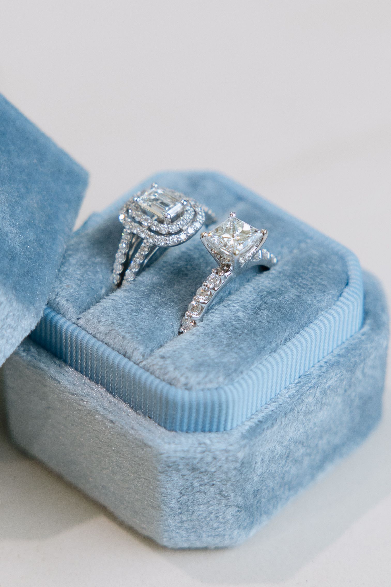 Two diamond rings in a light blue velvet ring box.