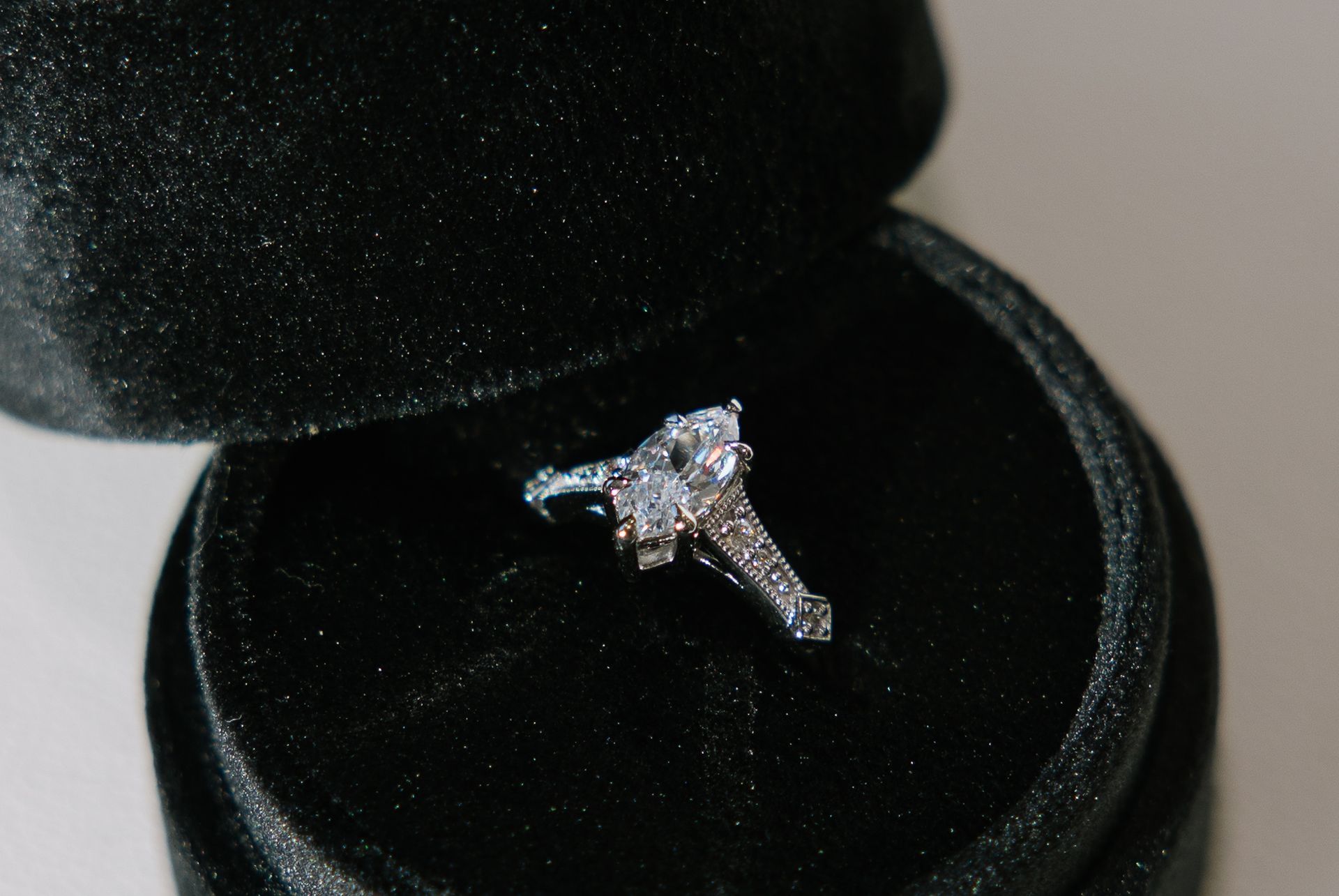 Diamond ring with large square center stone in a black velvet ring box.