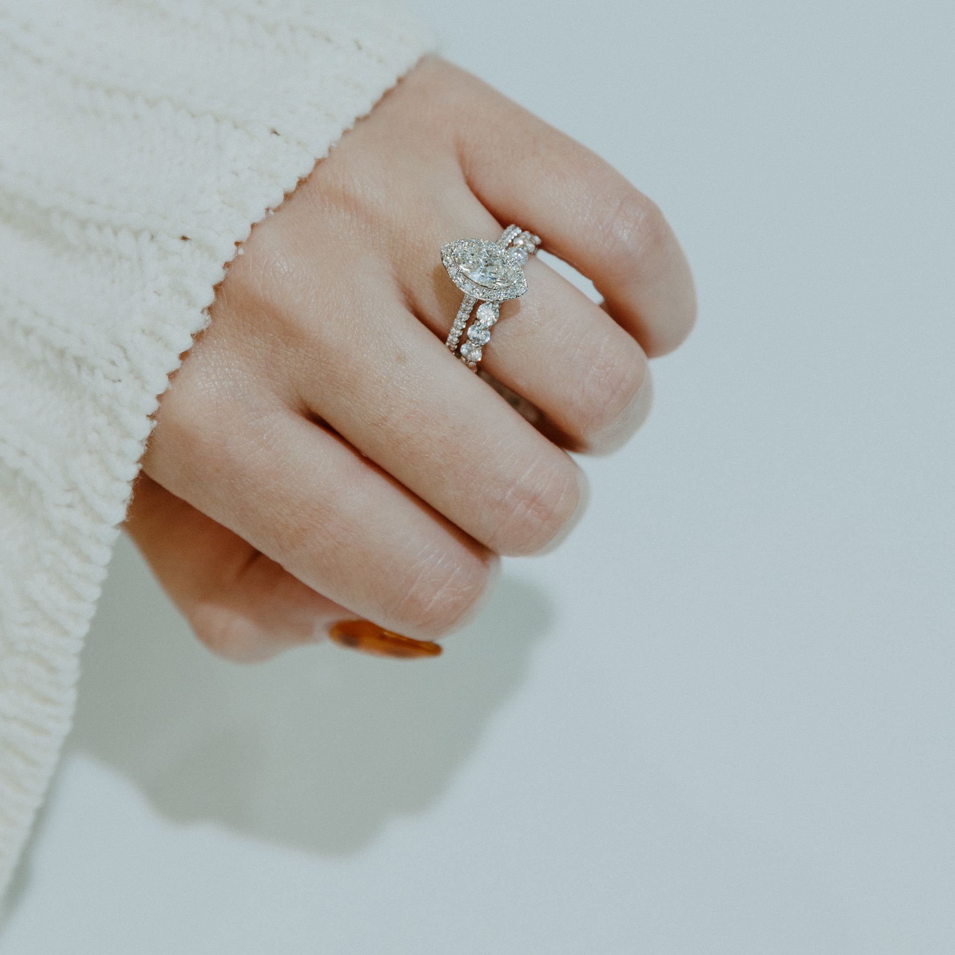 Hand wearing a diamond heart-shaped engagement ring with a diamond band.