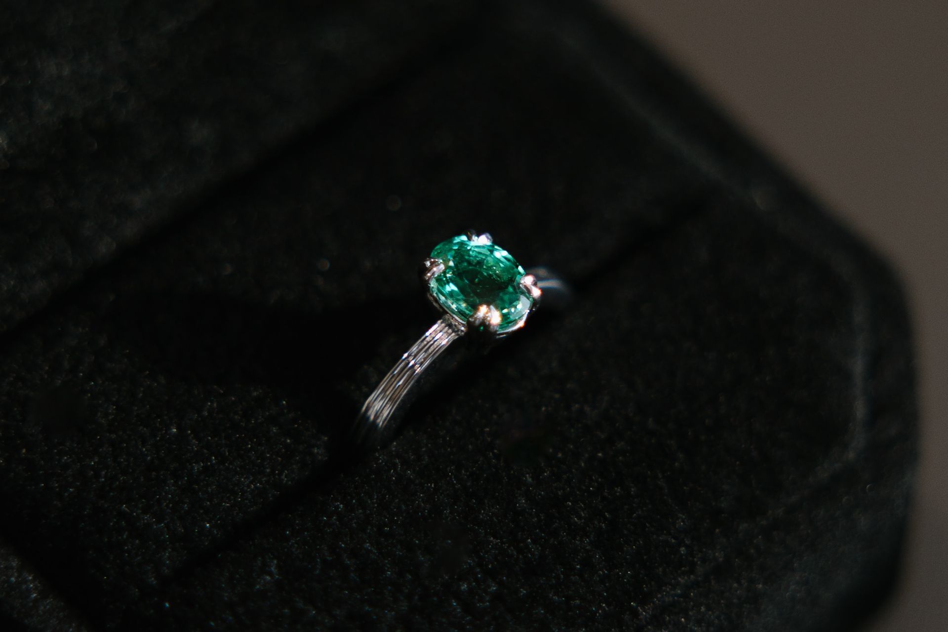 Emerald ring on a black velvet background.