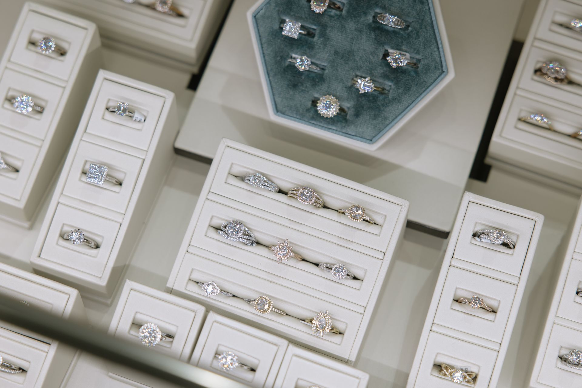 Jewelry display case with several diamond rings in various settings.