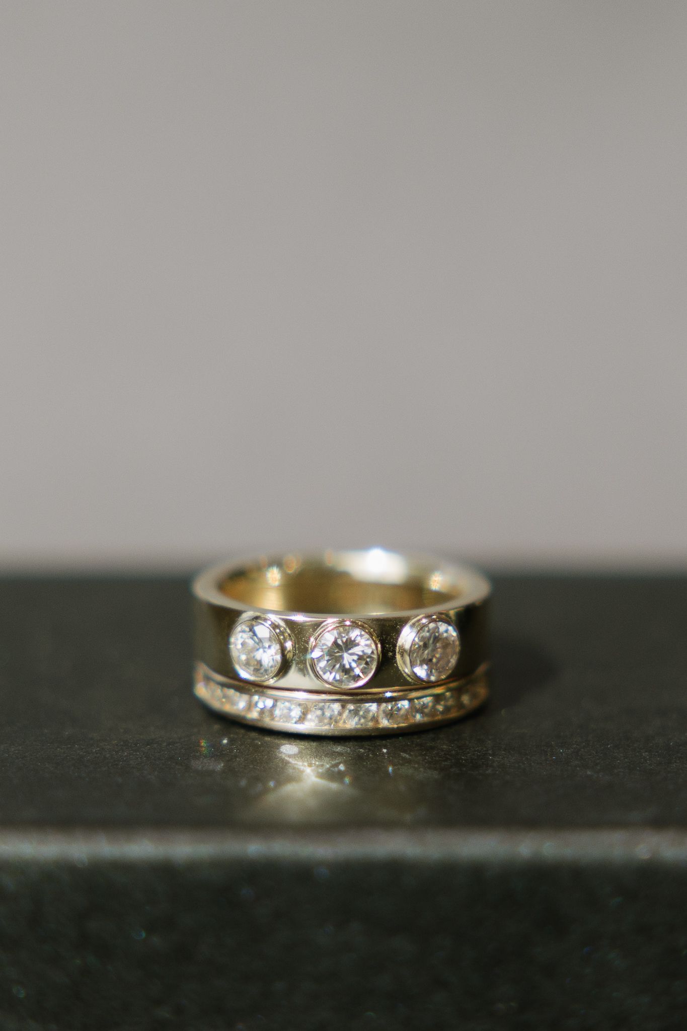 Gold ring with three large clear stones and a band of smaller stones.