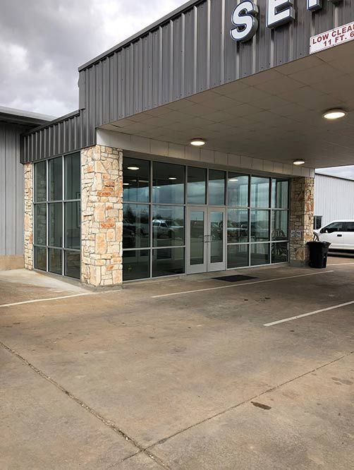 A large building with a lot of windows and a parking lot in front of it.