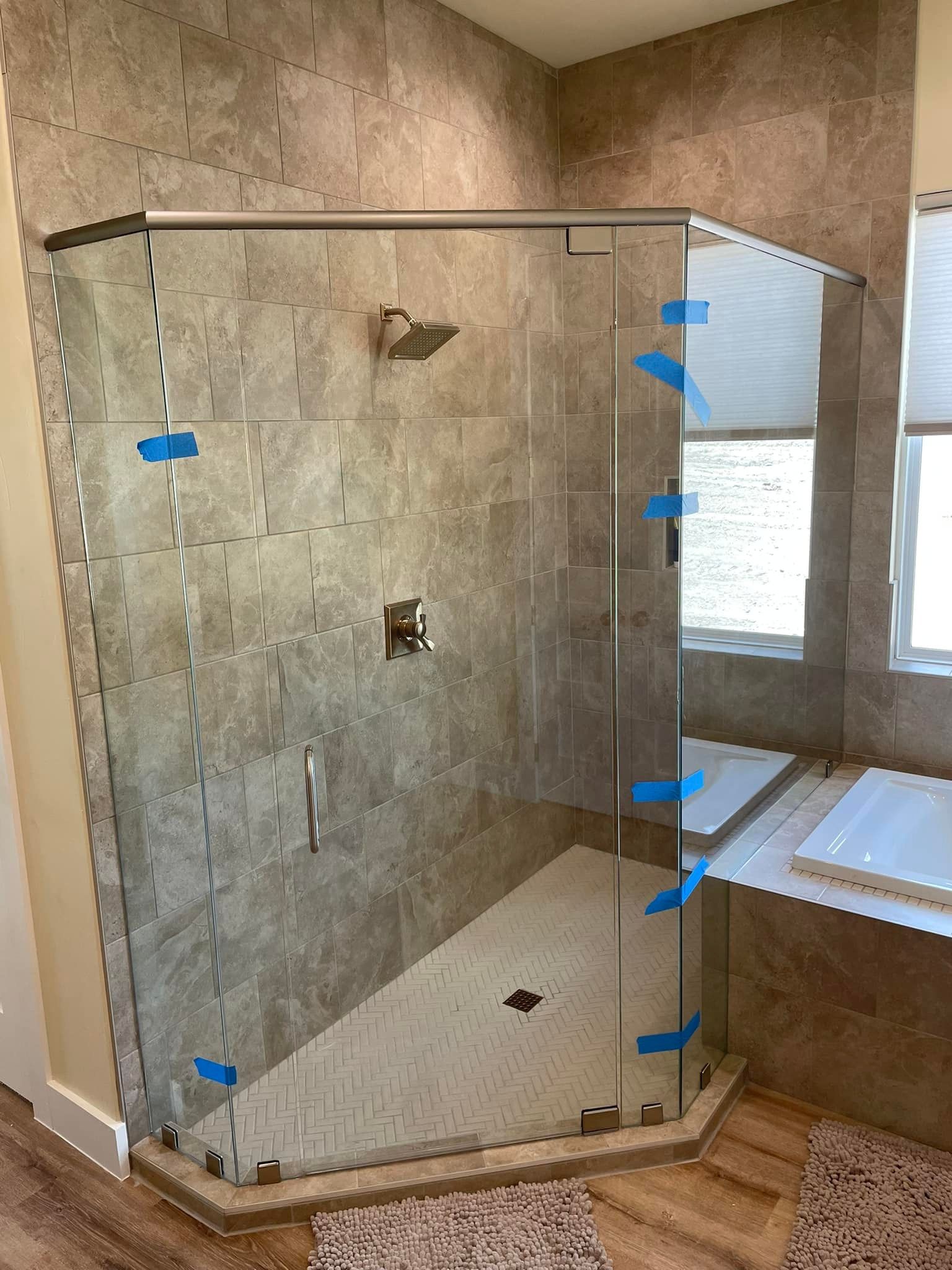 A bathroom with a walk in shower with a glass door.