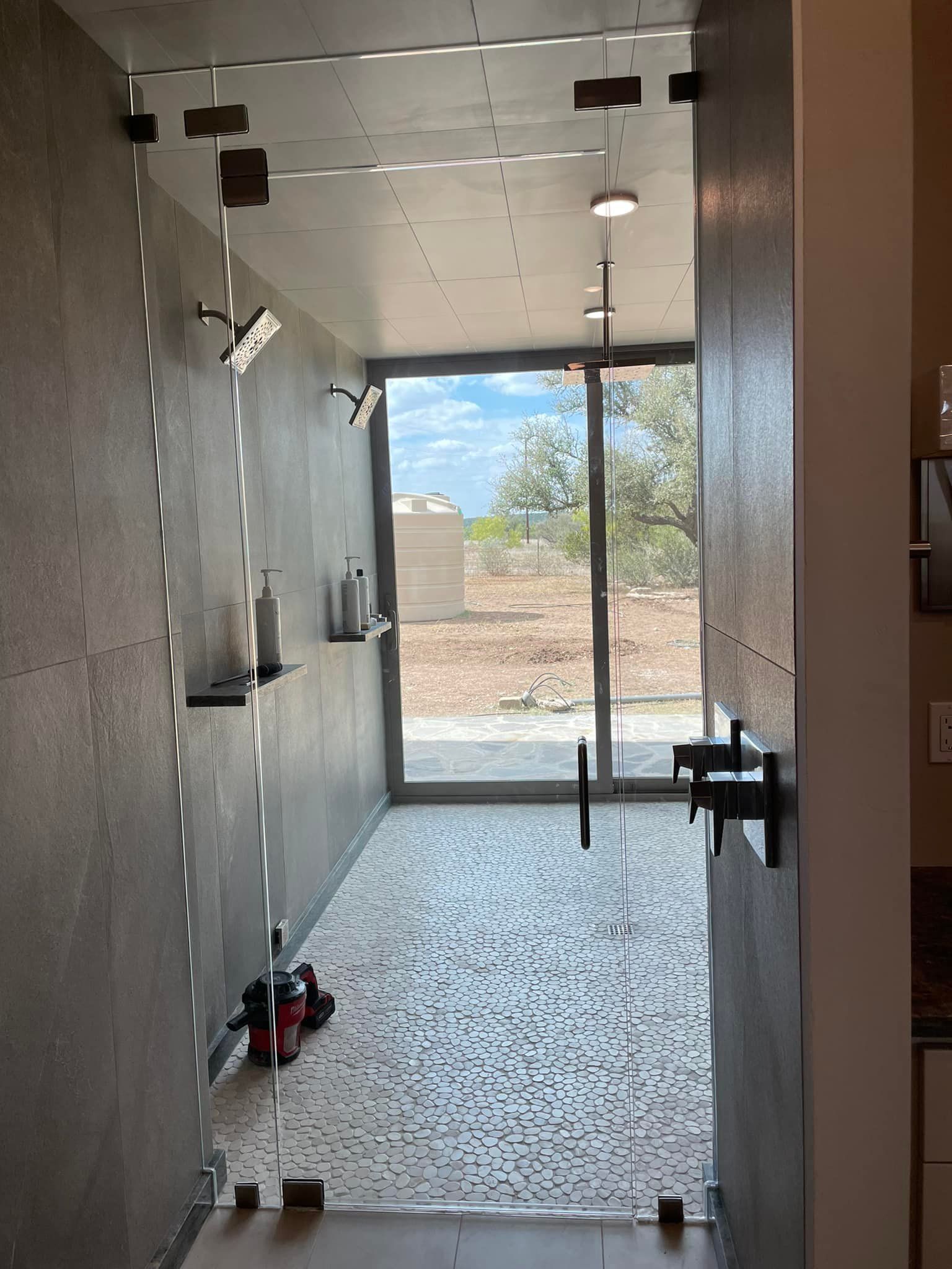 A bathroom with a sliding glass door and a large window.