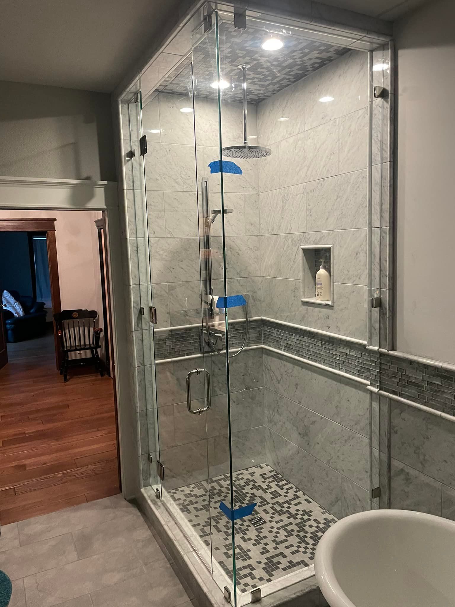 A bathroom with a walk in shower and a tub.