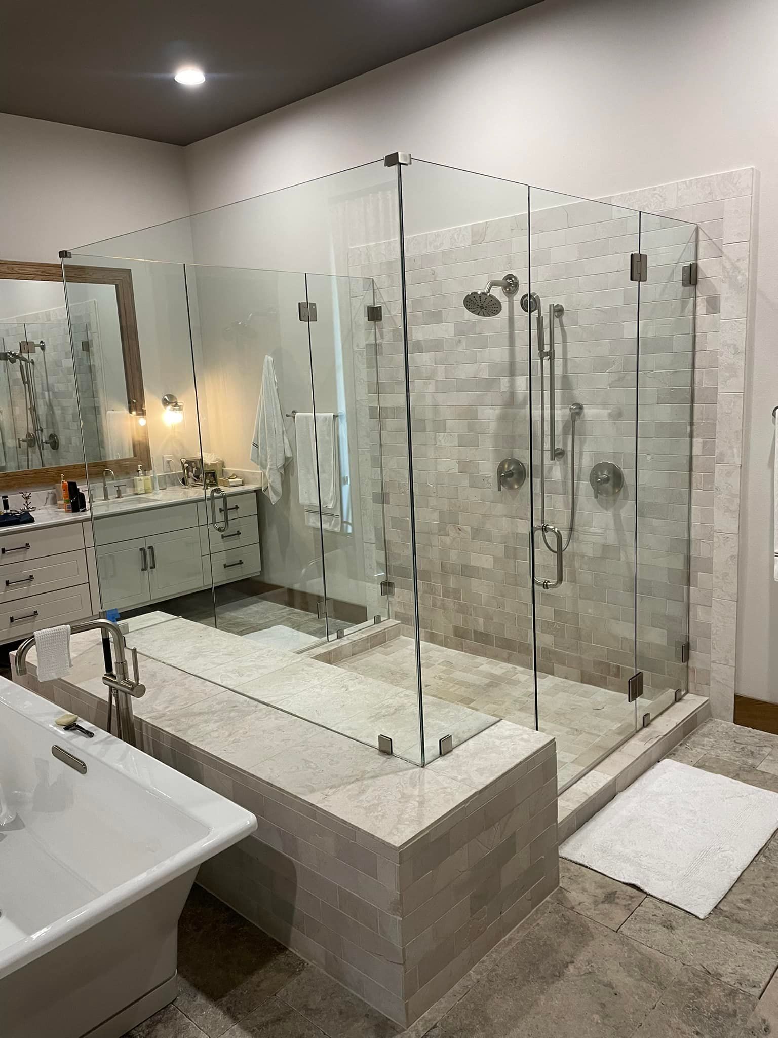 A bathroom with a walk in shower and a bathtub.
