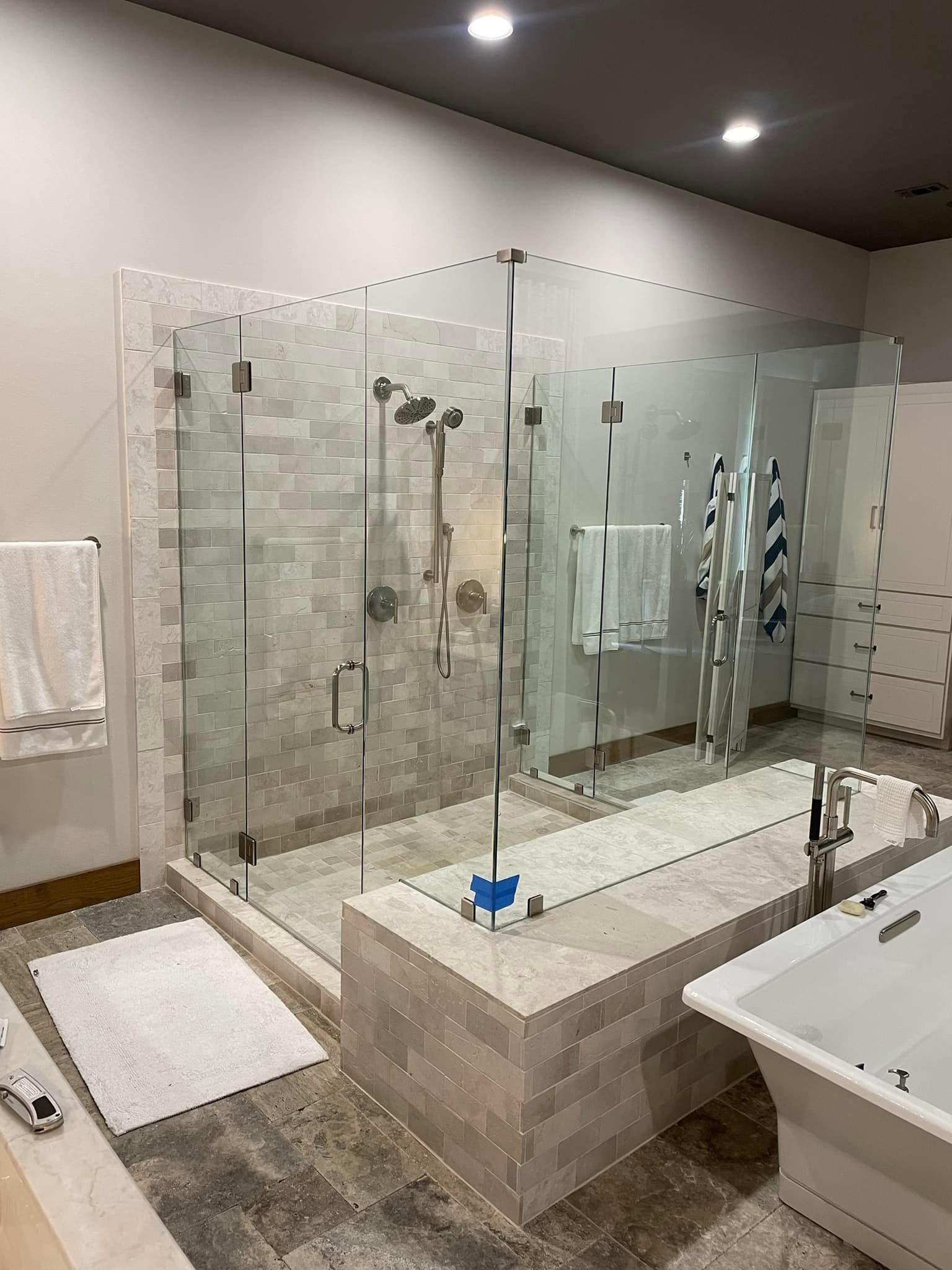 A bathroom with a walk in shower and a bathtub.