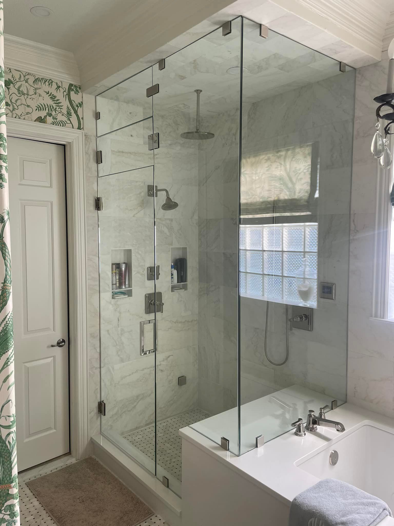 A bathroom with a walk in shower and a bathtub.