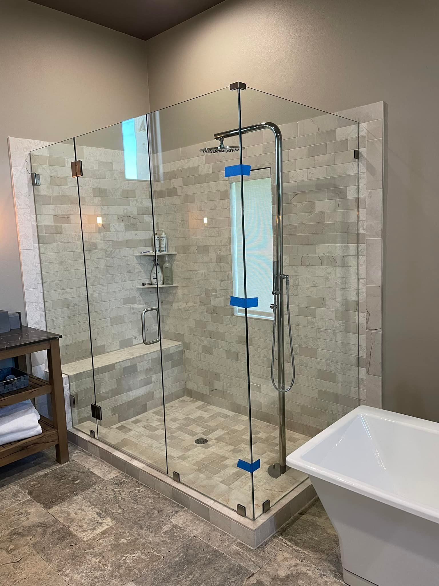 A bathroom with a walk in shower and a bathtub.