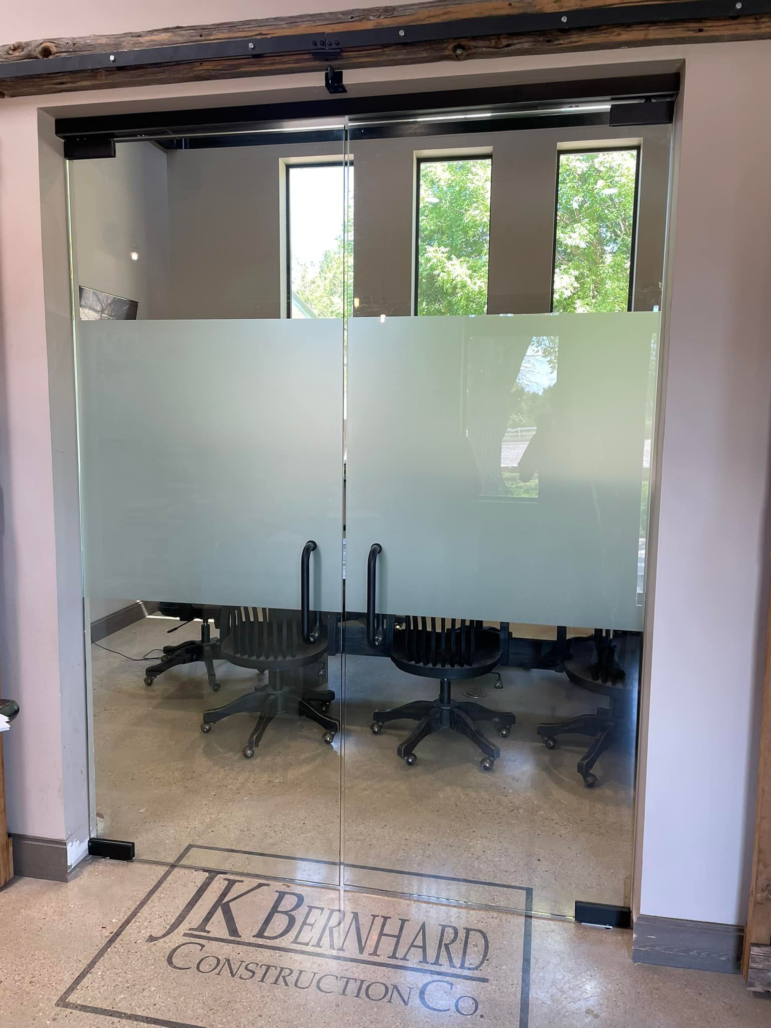 A room with a glass door and a sign that says k bernhard