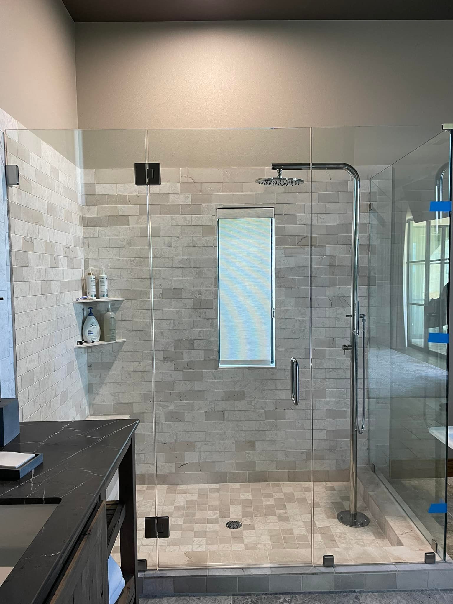 A bathroom with a walk in shower and a sink.