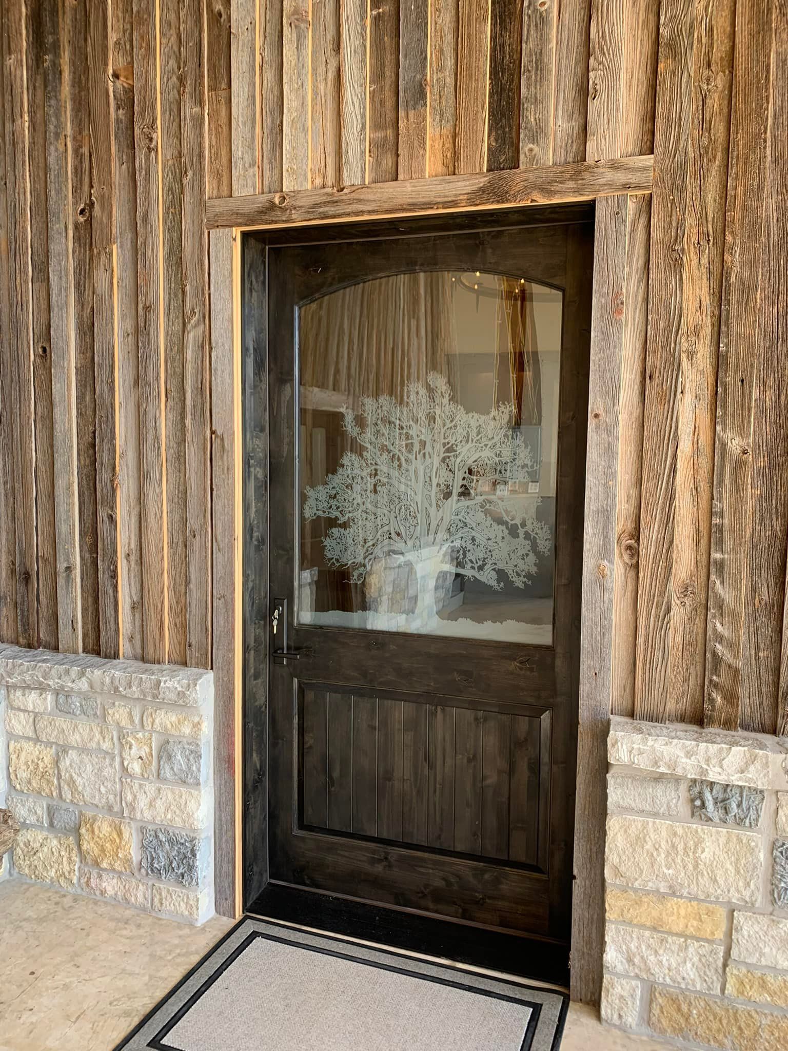 A wooden door with a glass window is surrounded by a stone wall.