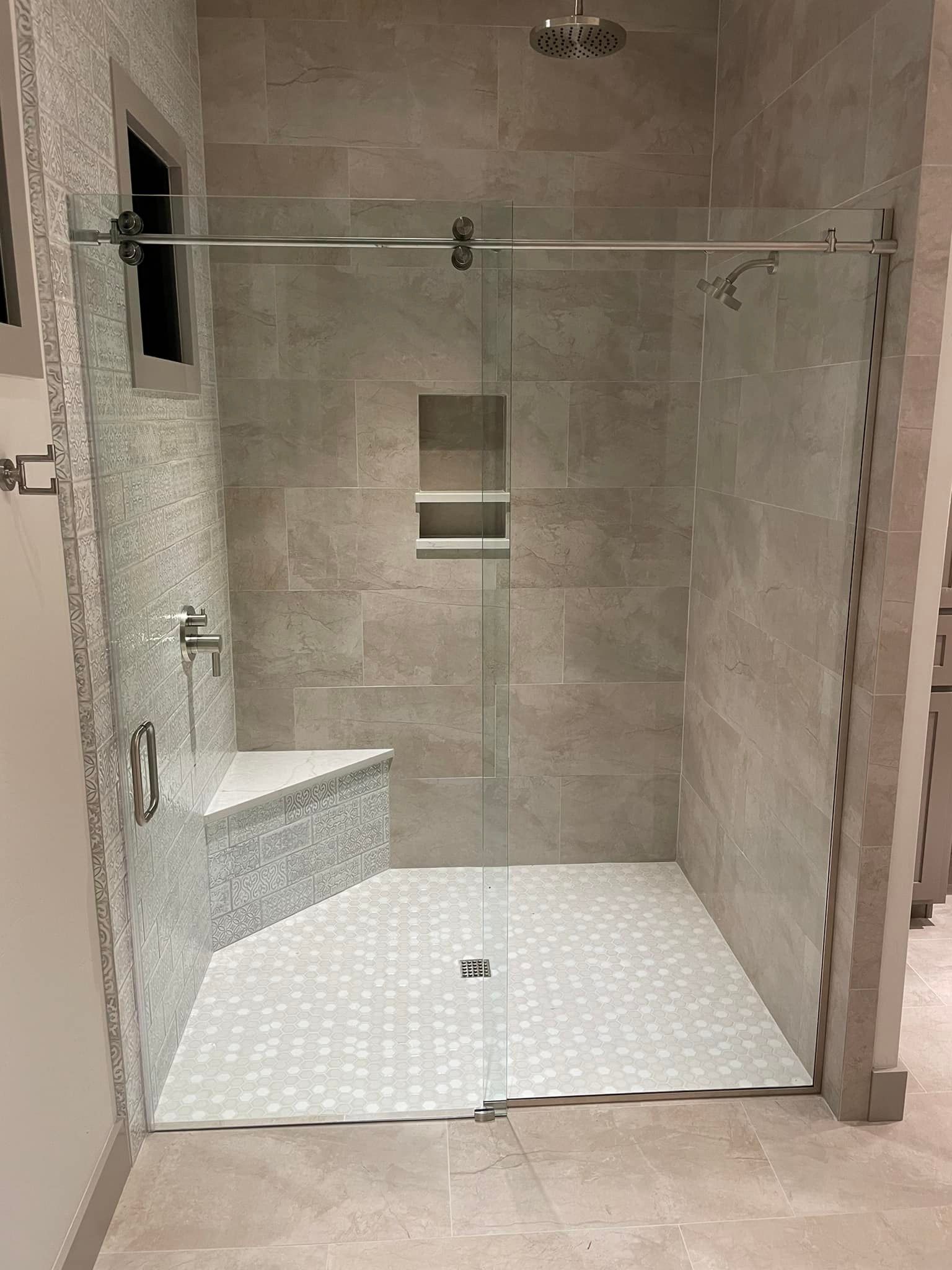 A bathroom with a walk in shower with a sliding glass door.