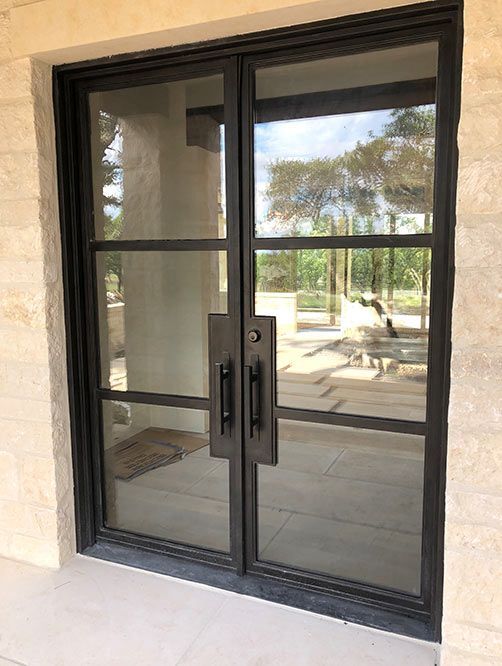 A door with a lot of glass is sitting on a tiled floor.
