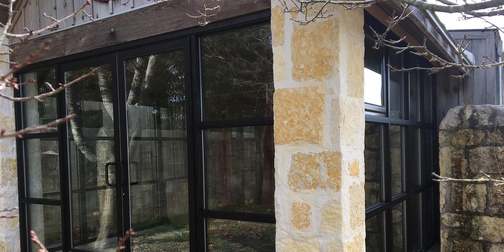 A building with a lot of windows and a stone wall.