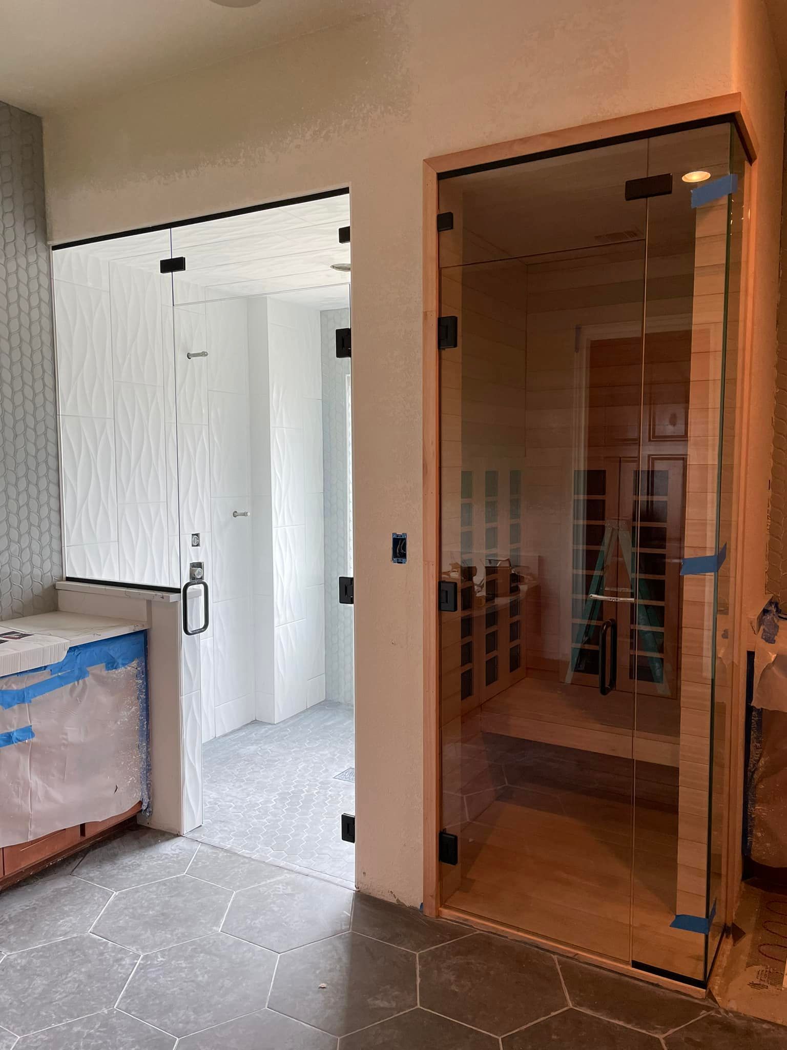 A bathroom with a glass door leading to a sauna.