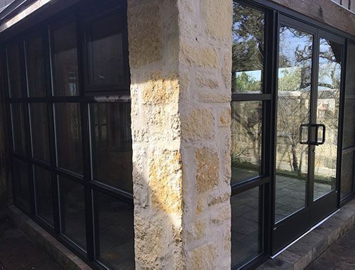 A building with a lot of windows and a stone wall.