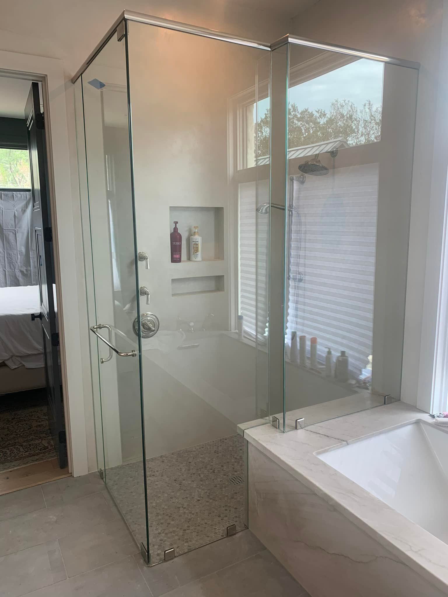 A bathroom with a walk in shower and a bathtub.