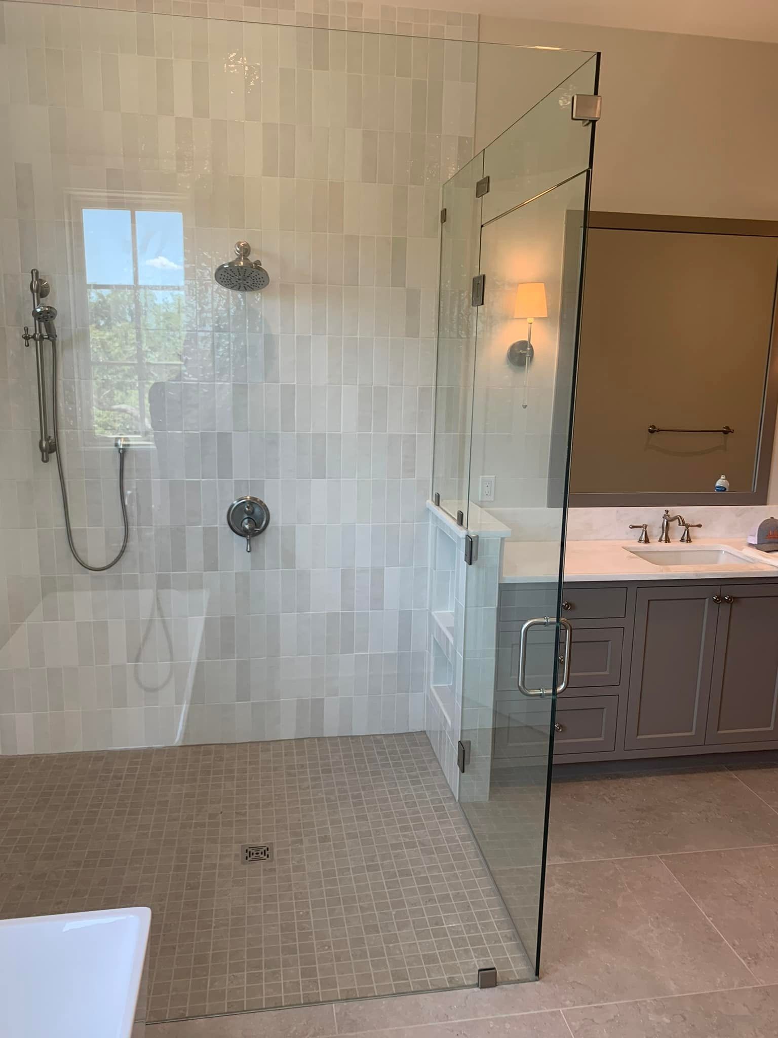 A bathroom with a walk in shower and a sink.