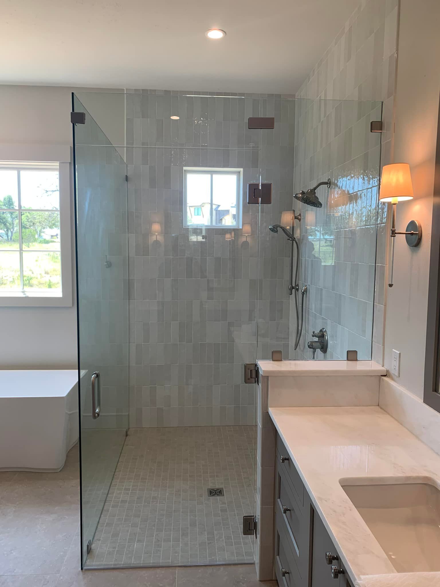 A bathroom with a walk in shower and a sink.