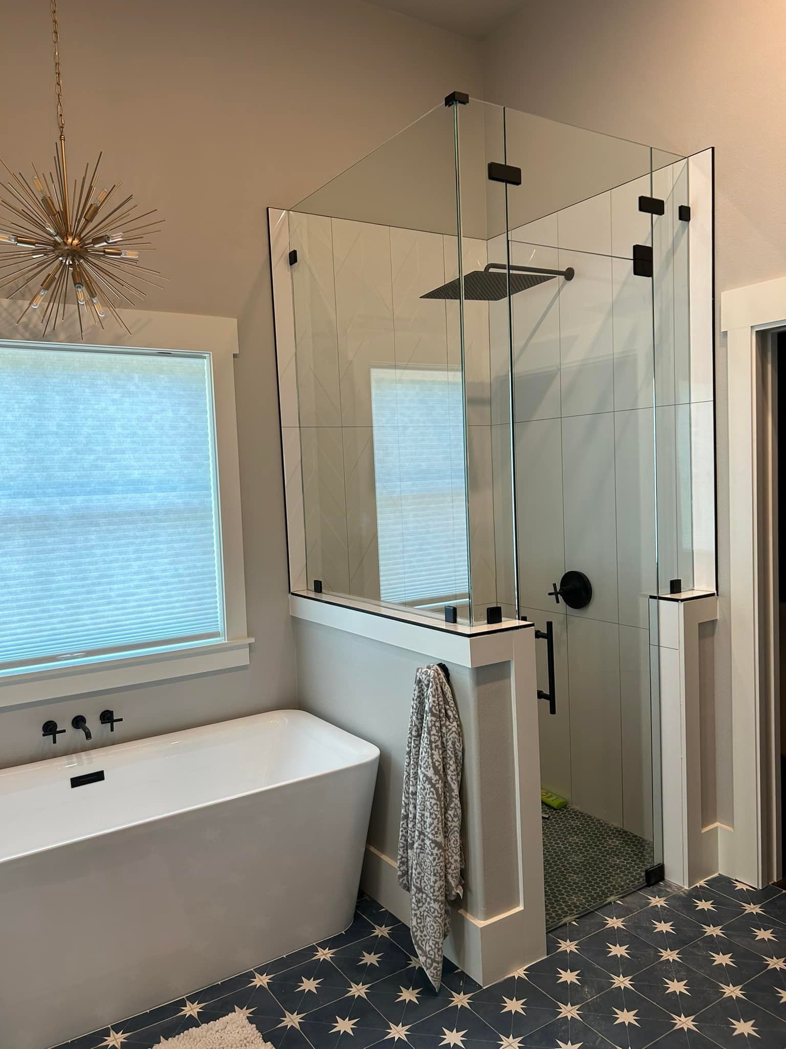 A bathroom with a bathtub , shower , and window.