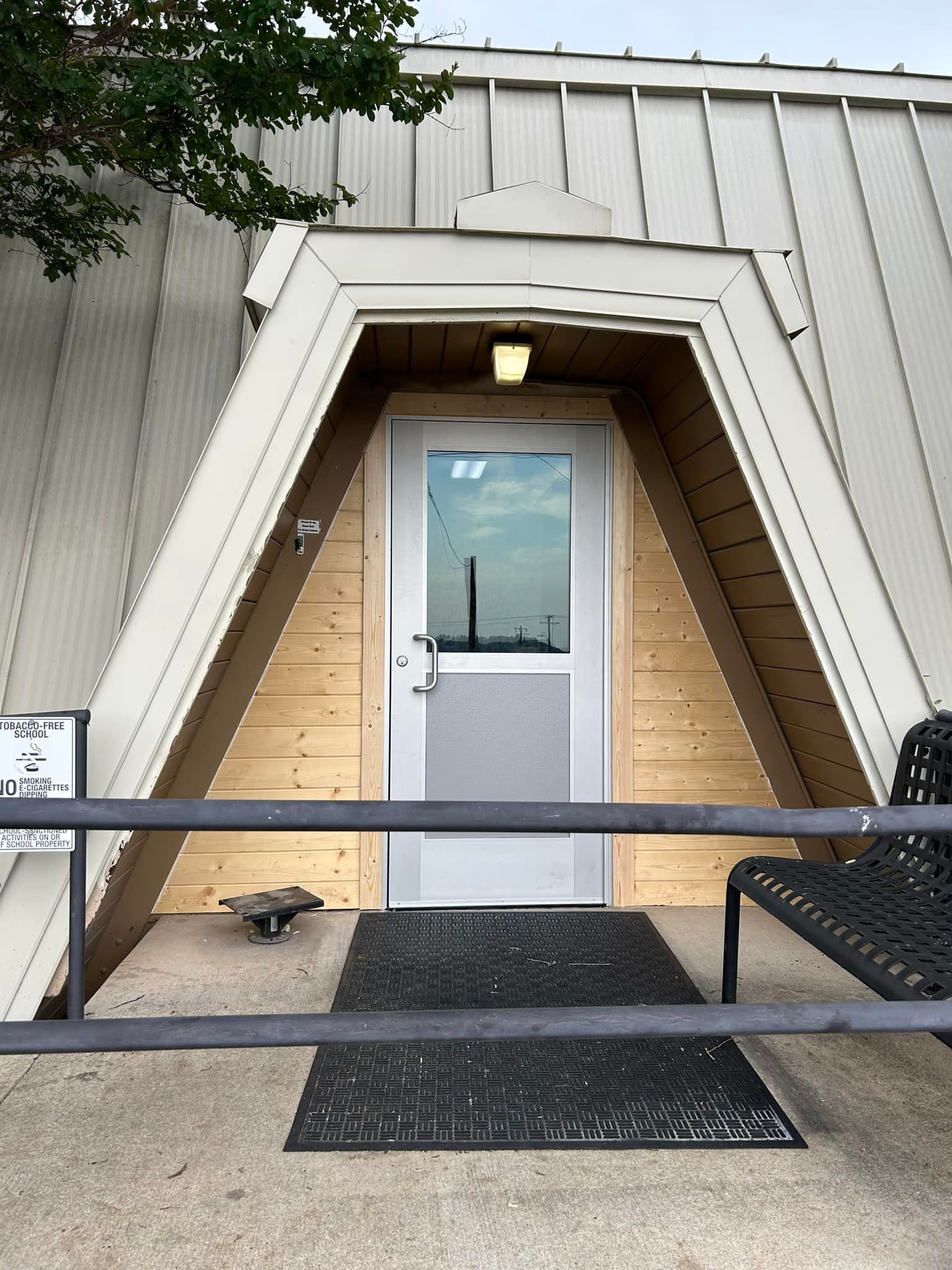 A triangle shaped building with a white door