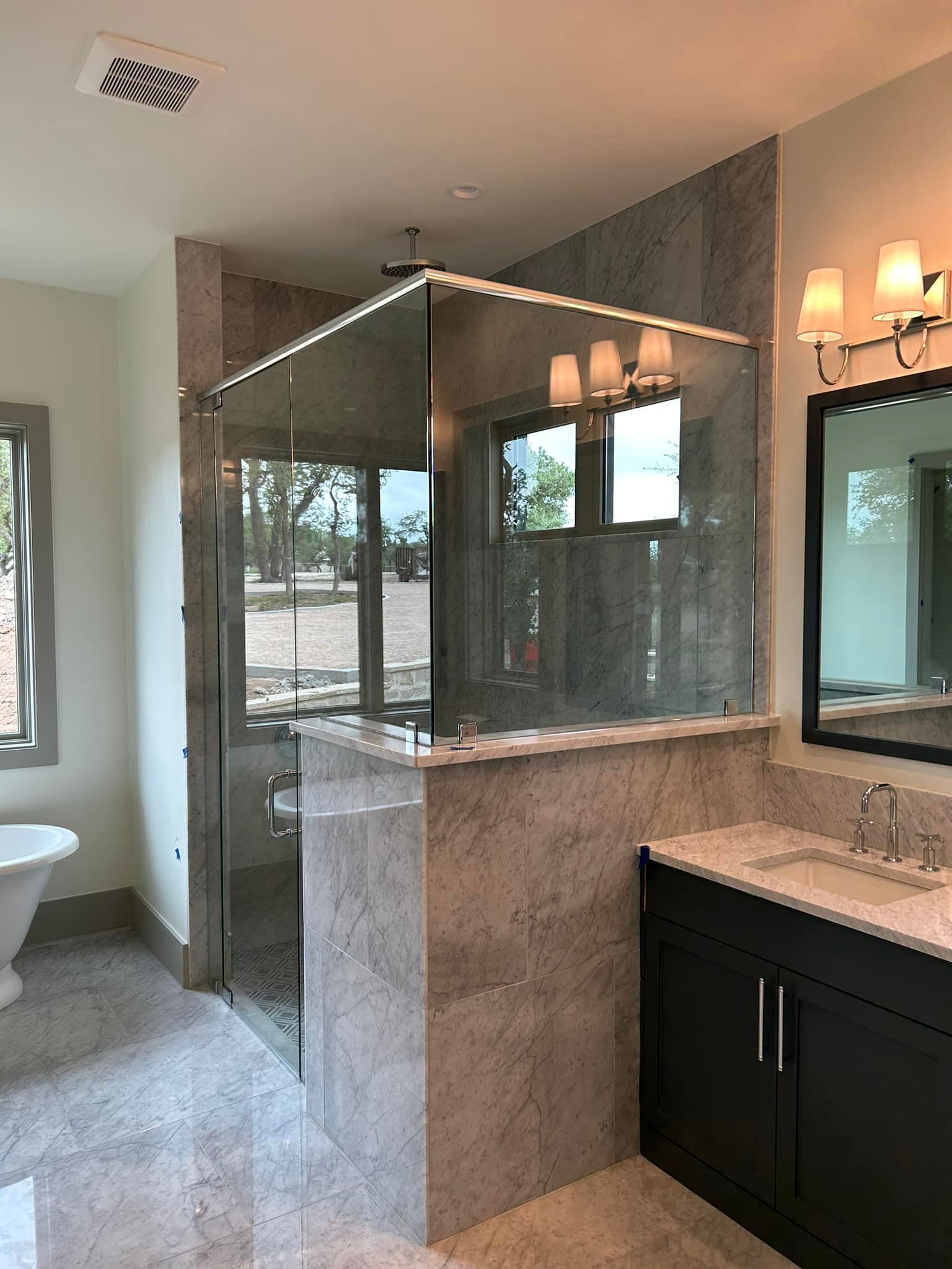 A bathroom with a walk in shower , sink , and mirror.