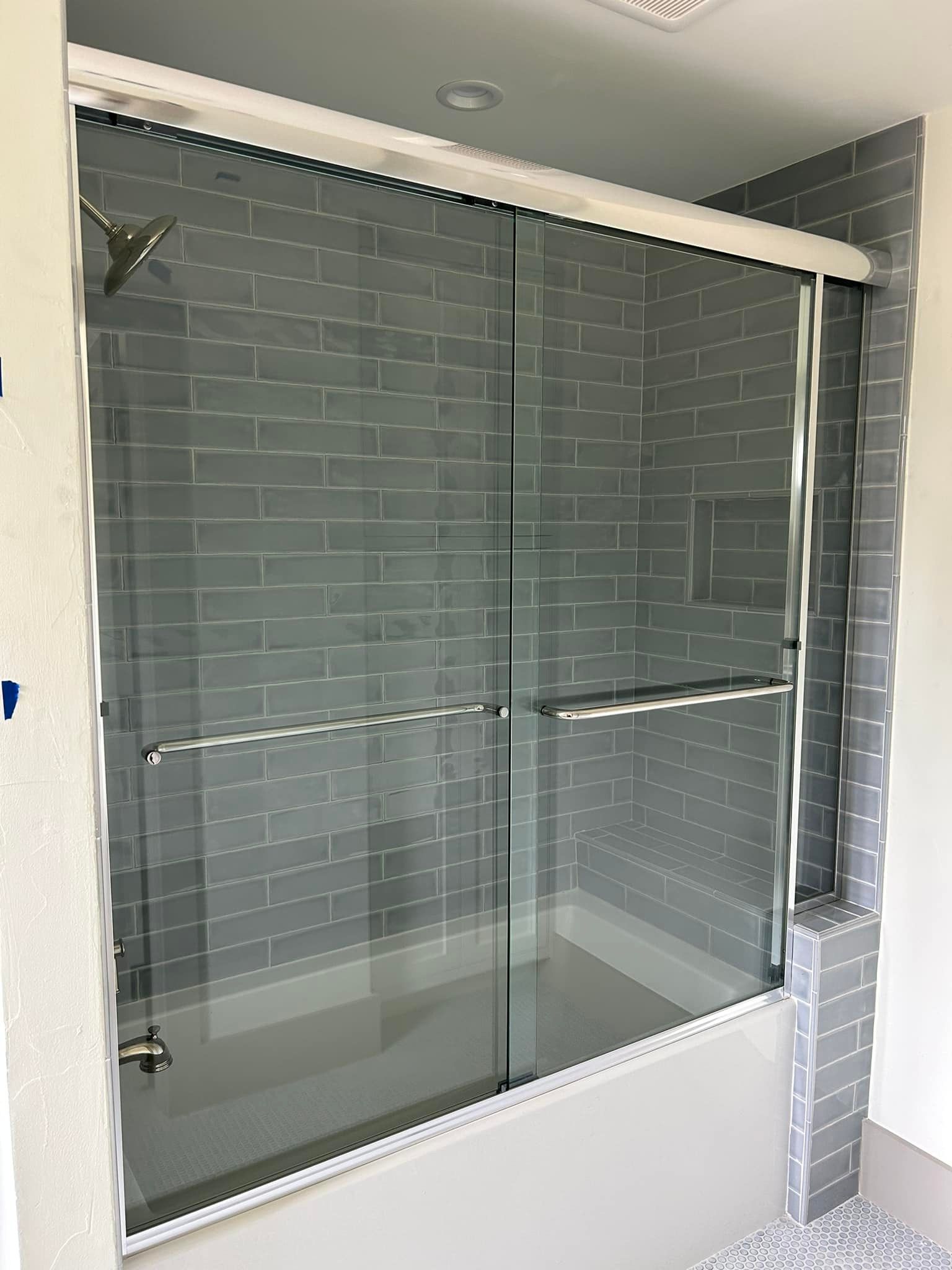 A bathroom with a bathtub and a sliding glass shower door.