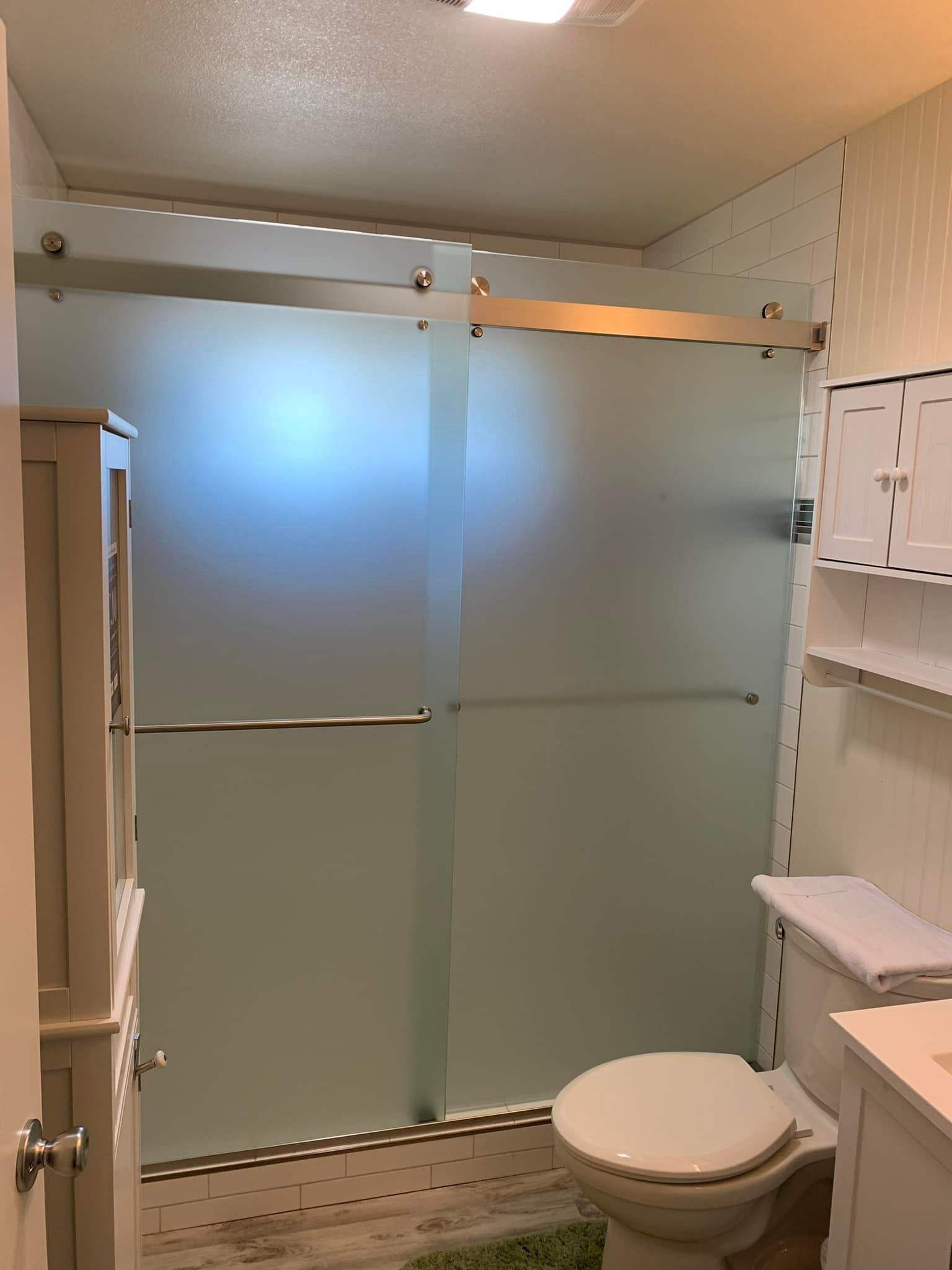 A bathroom with a toilet and a glass shower door.