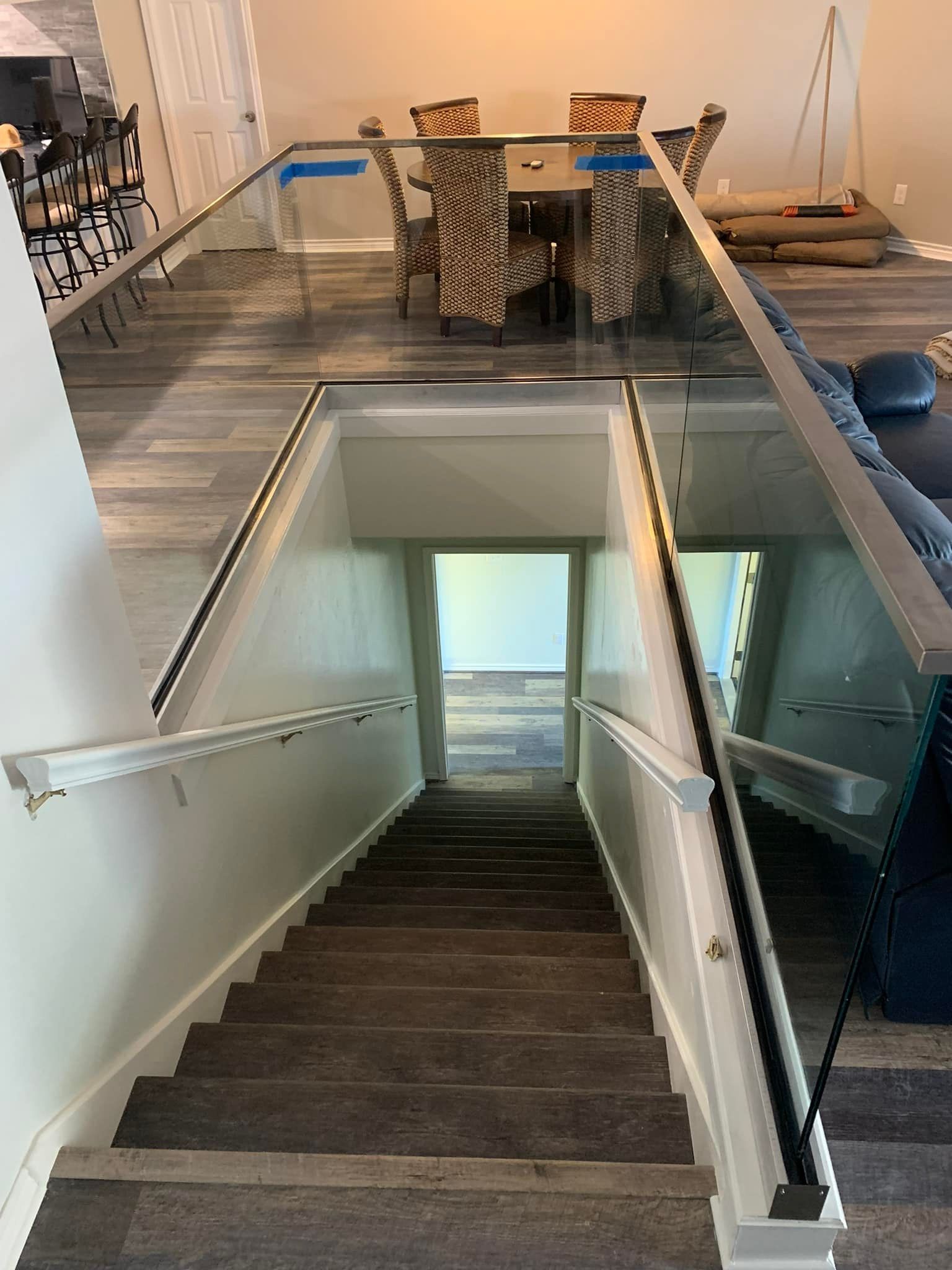 A set of stairs leading up to a dining room with a glass railing.