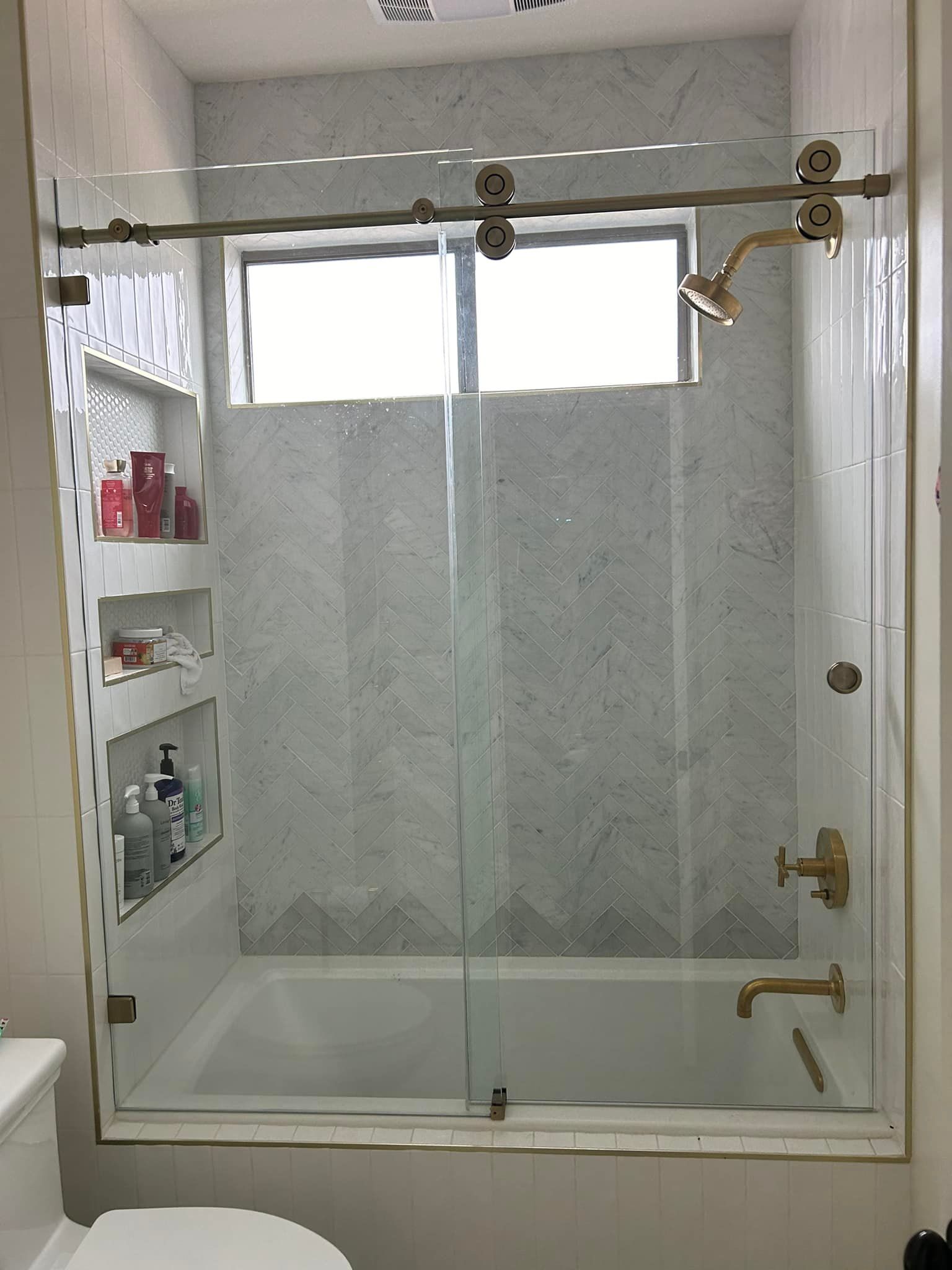 A bathroom with a sliding glass shower door and a bathtub.