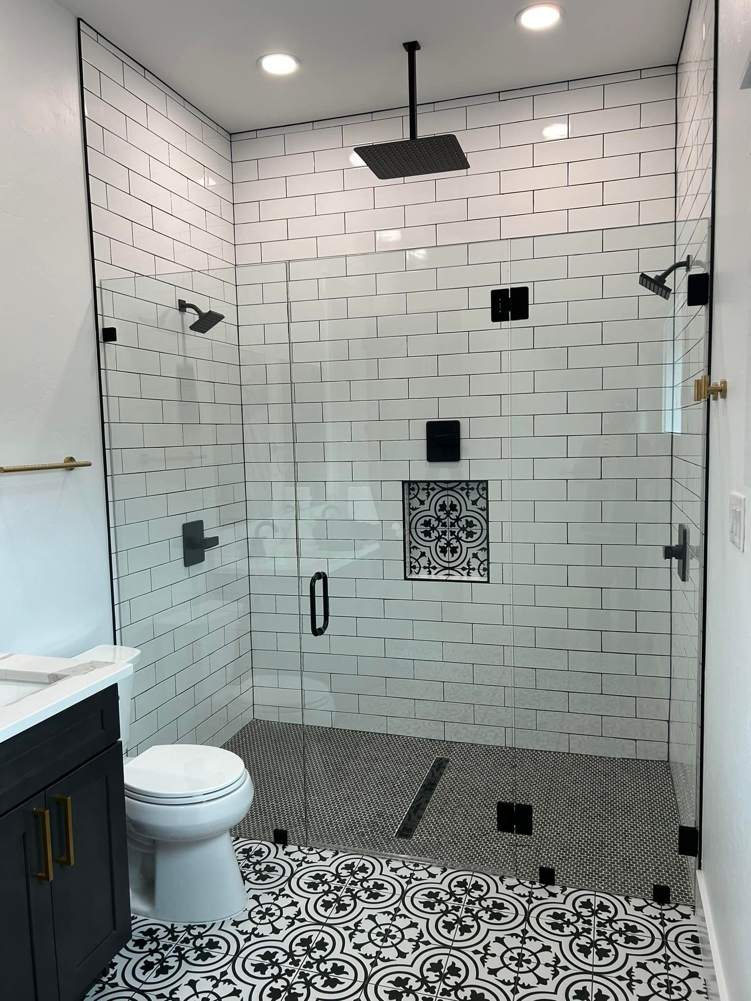 A bathroom with a walk in shower , toilet and sink.