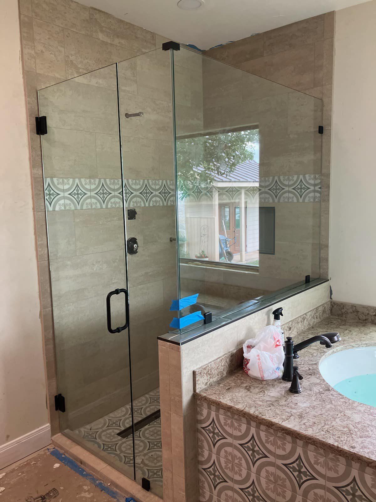 A bathroom with a glass shower door and a sink.