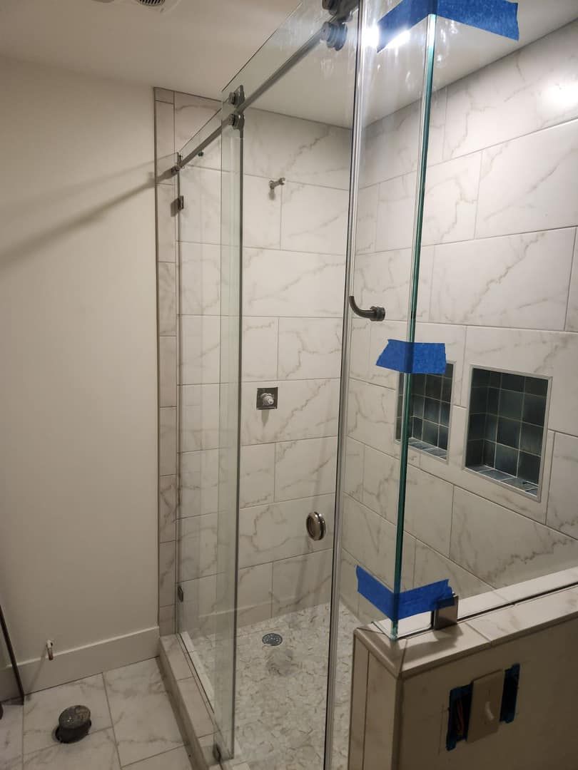 A bathroom with a sliding glass shower door.