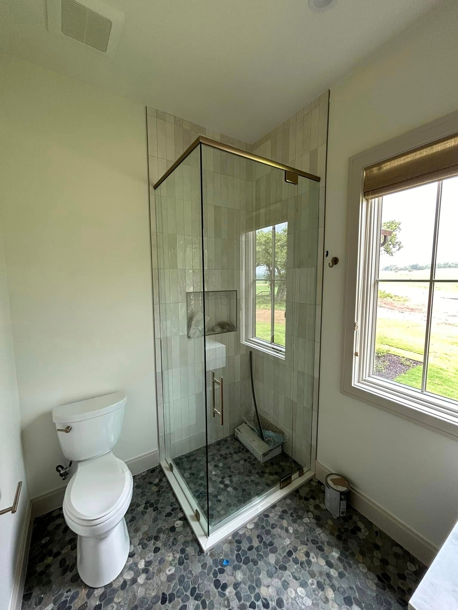 A bathroom with a toilet , sink and walk in shower.